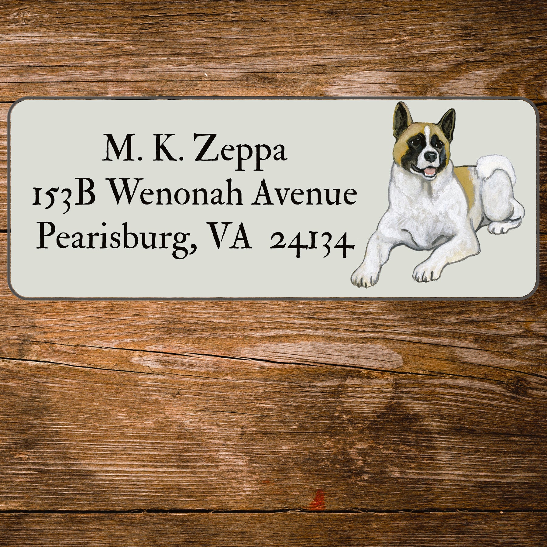 Address label with an Akita illustration on a wooden surface