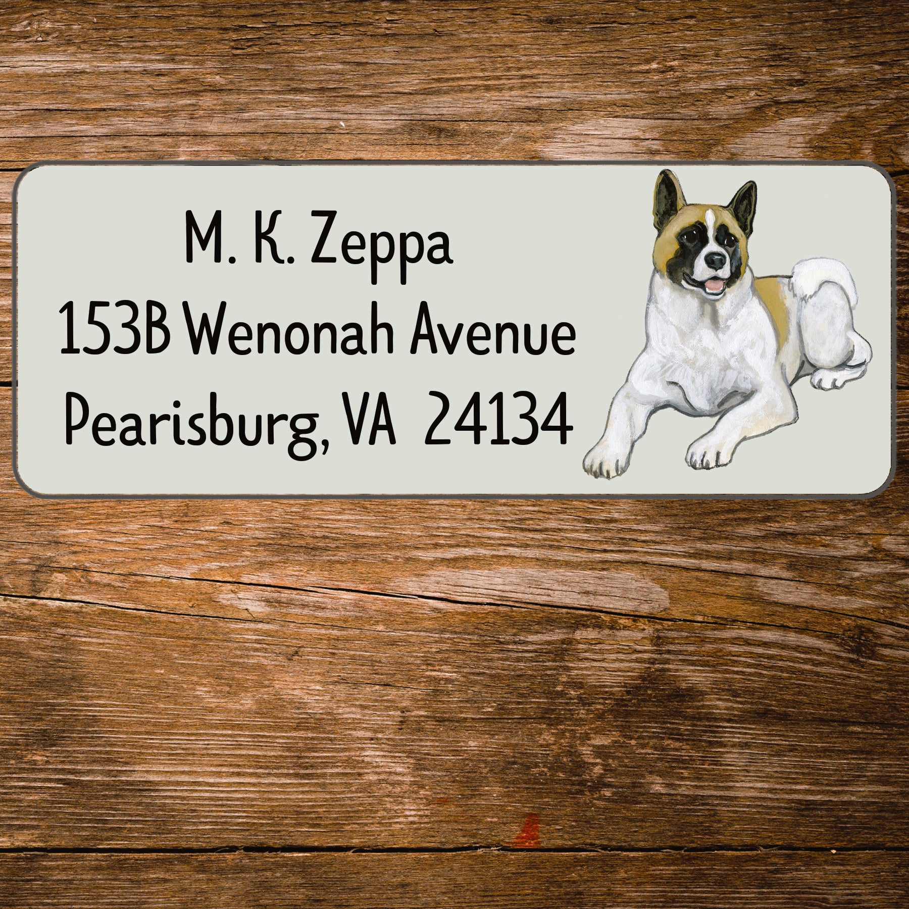 Address label with an Akita illustration on a wooden surface