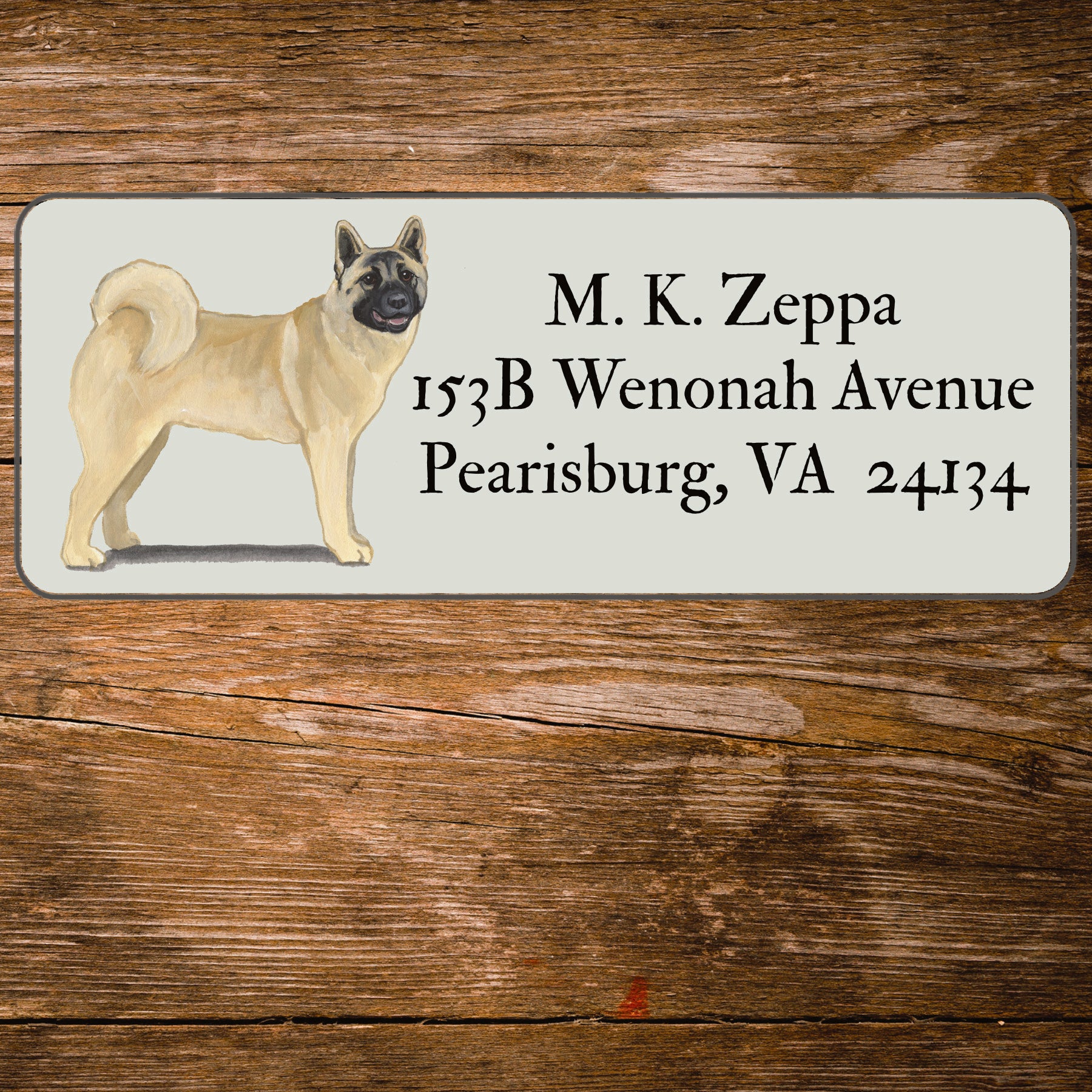 Address label with an Akita illustration on a wooden surface