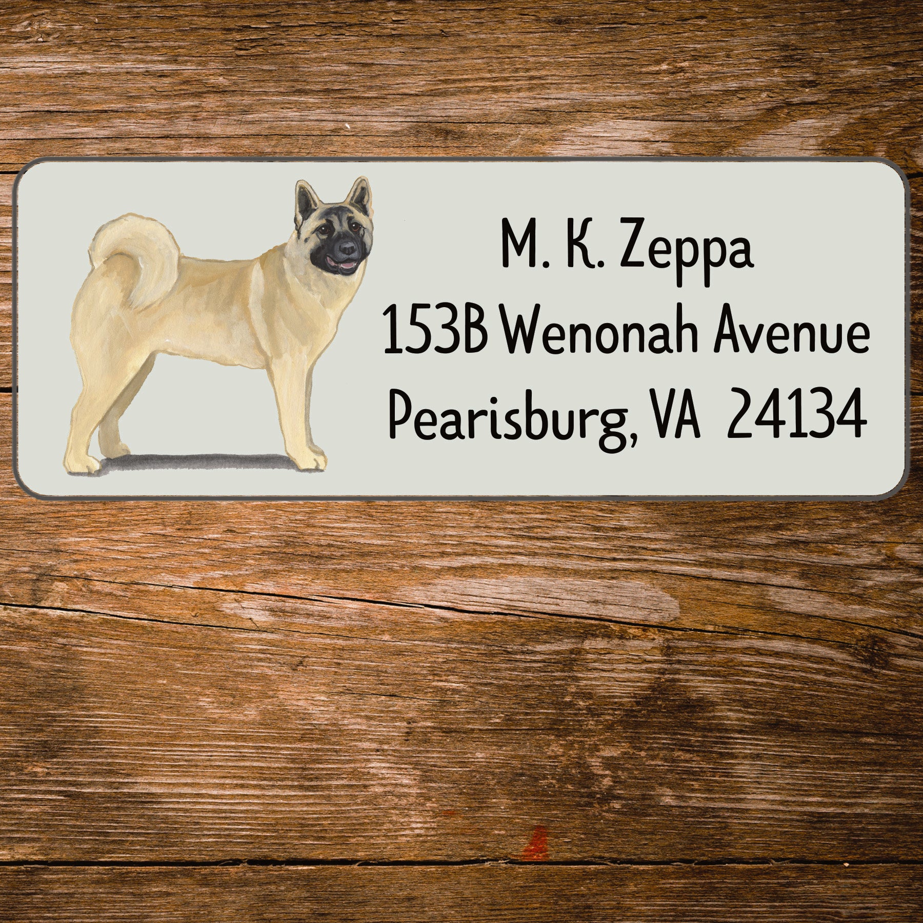 Address label with an Akita illustration on a wooden surface