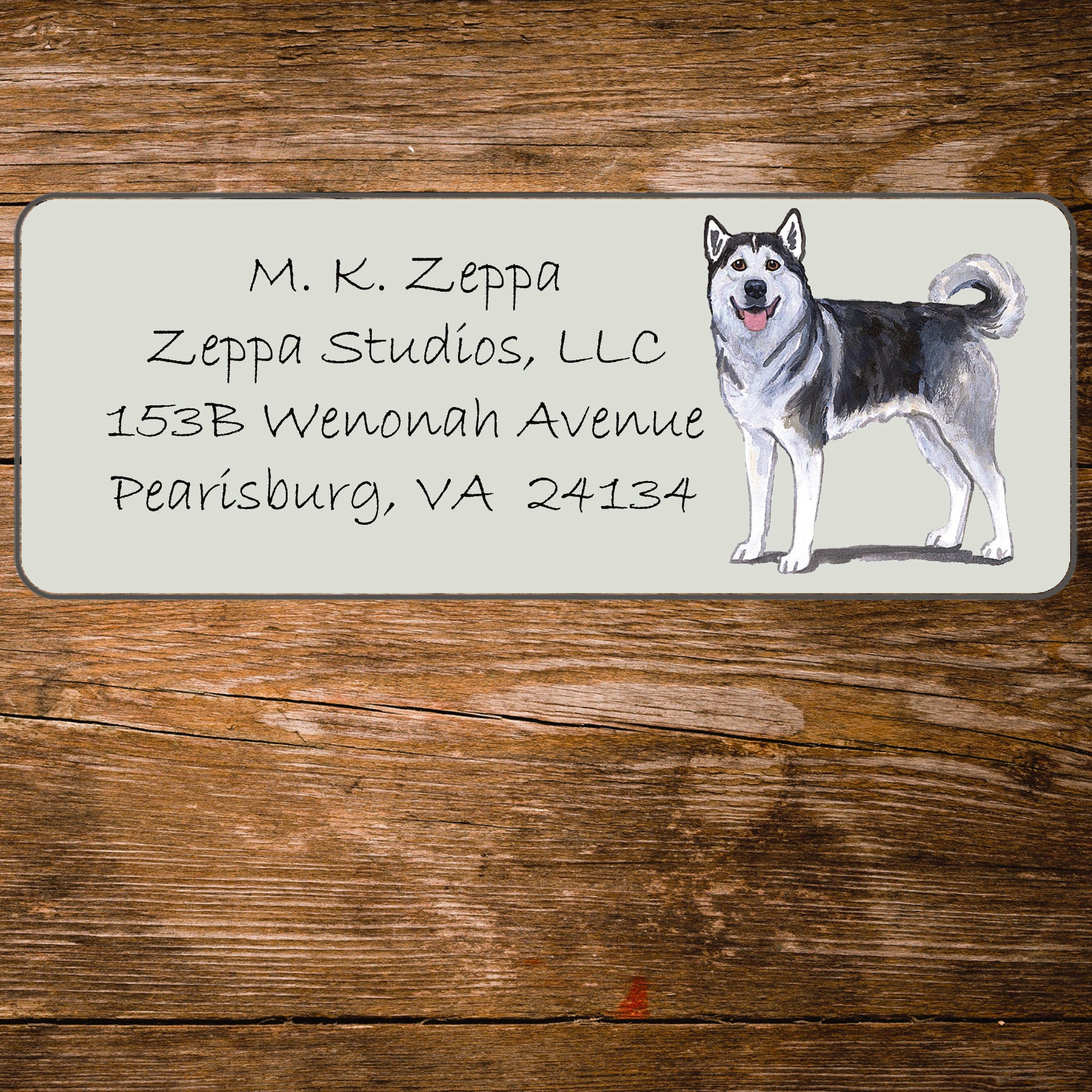 Address label with an Alaskan Malamute illustration on a wooden surface