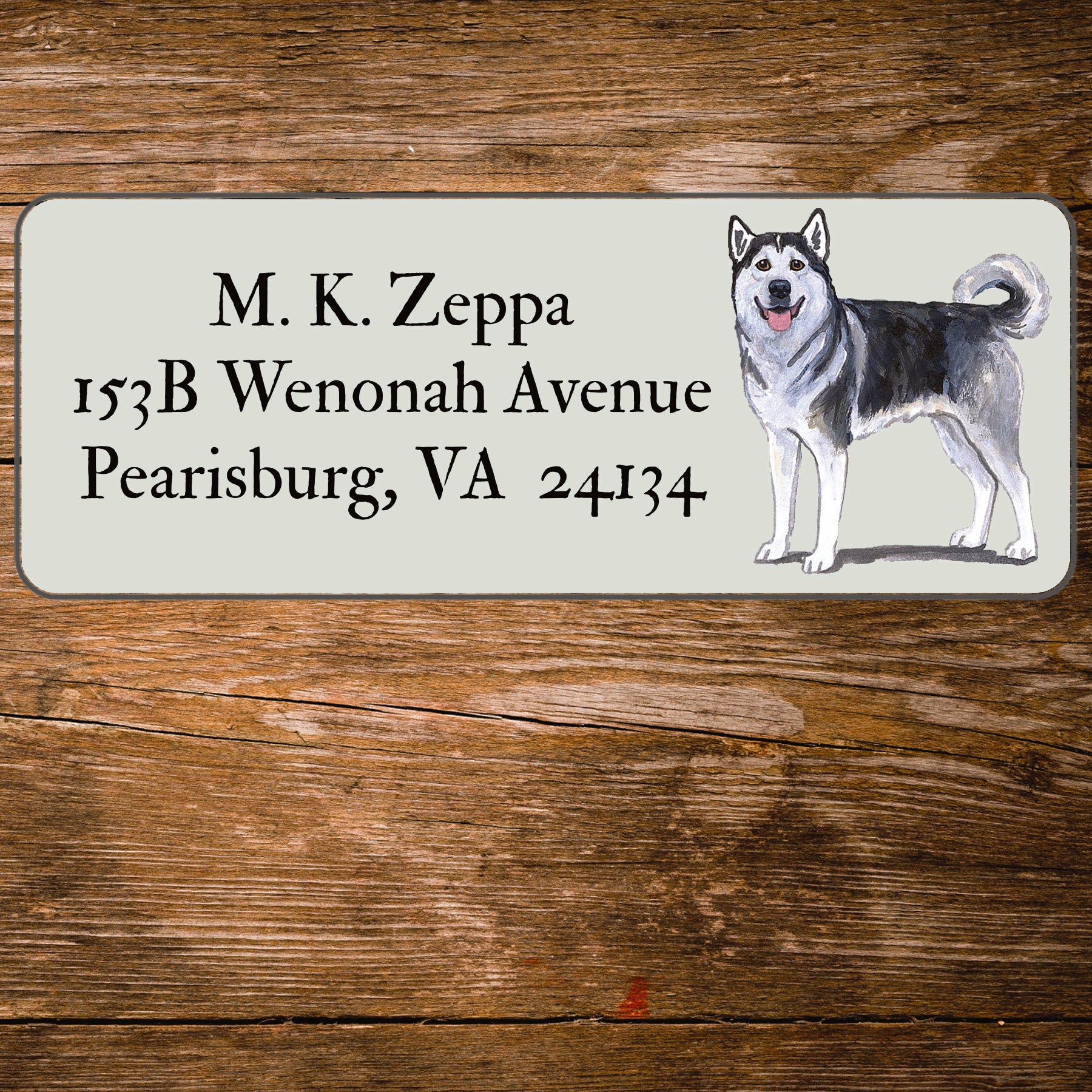 Address label with an Alaskan Malamute illustration on a wooden surface