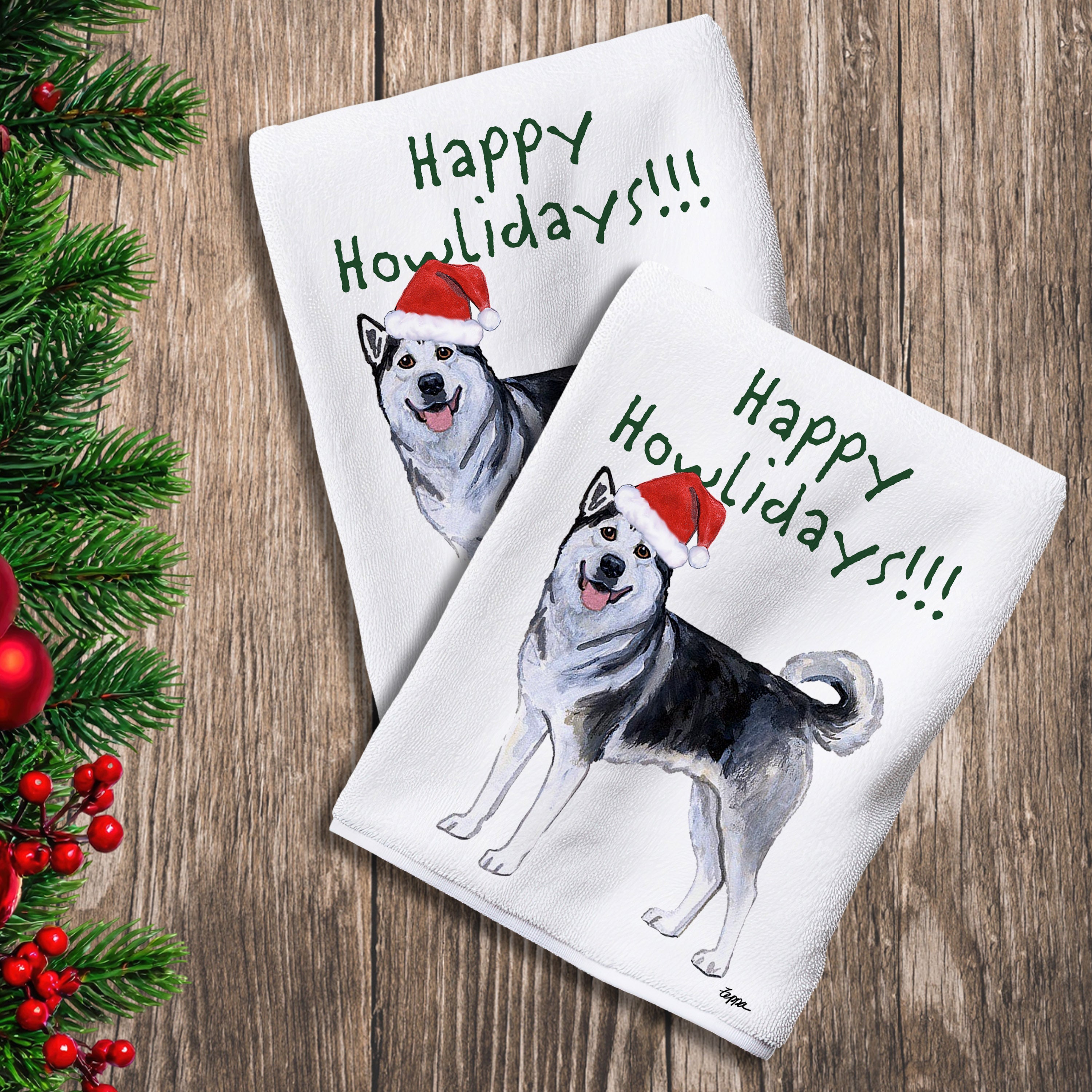 2 Kitchen Towels with an Alaskan Malamute in a Santa Hat and Happy Howlidays text.
