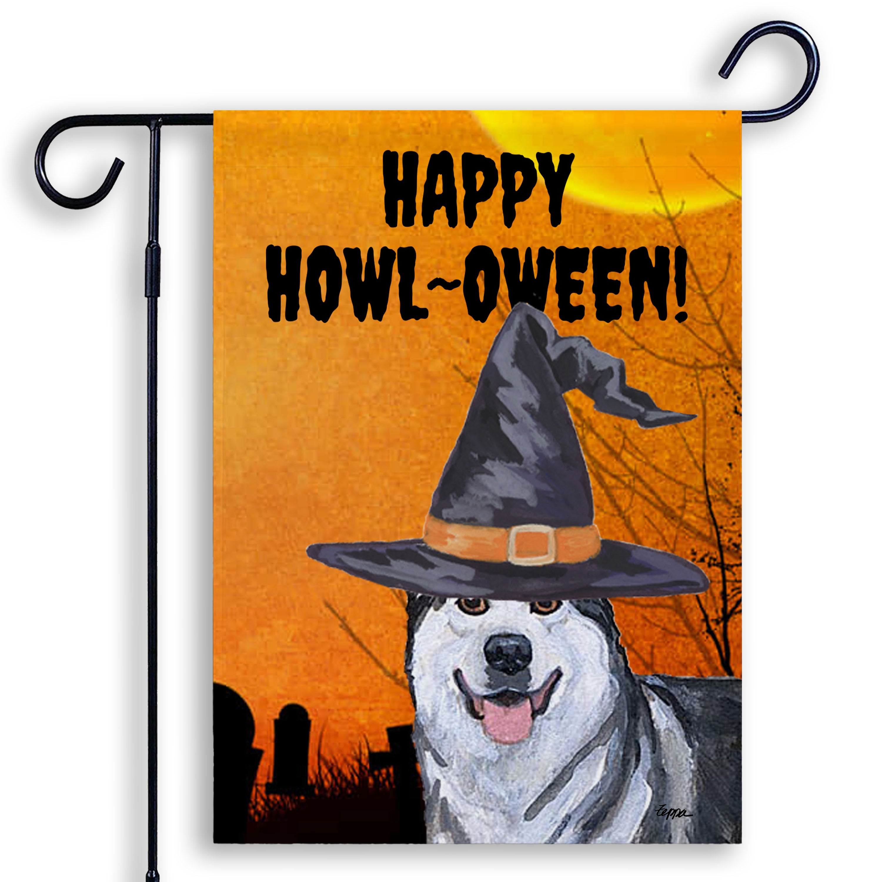 Halloween-themed garden flag with an Alaskan Malamute wearing a witch hat and 'Happy Howl-Oween!' text on an orange background.