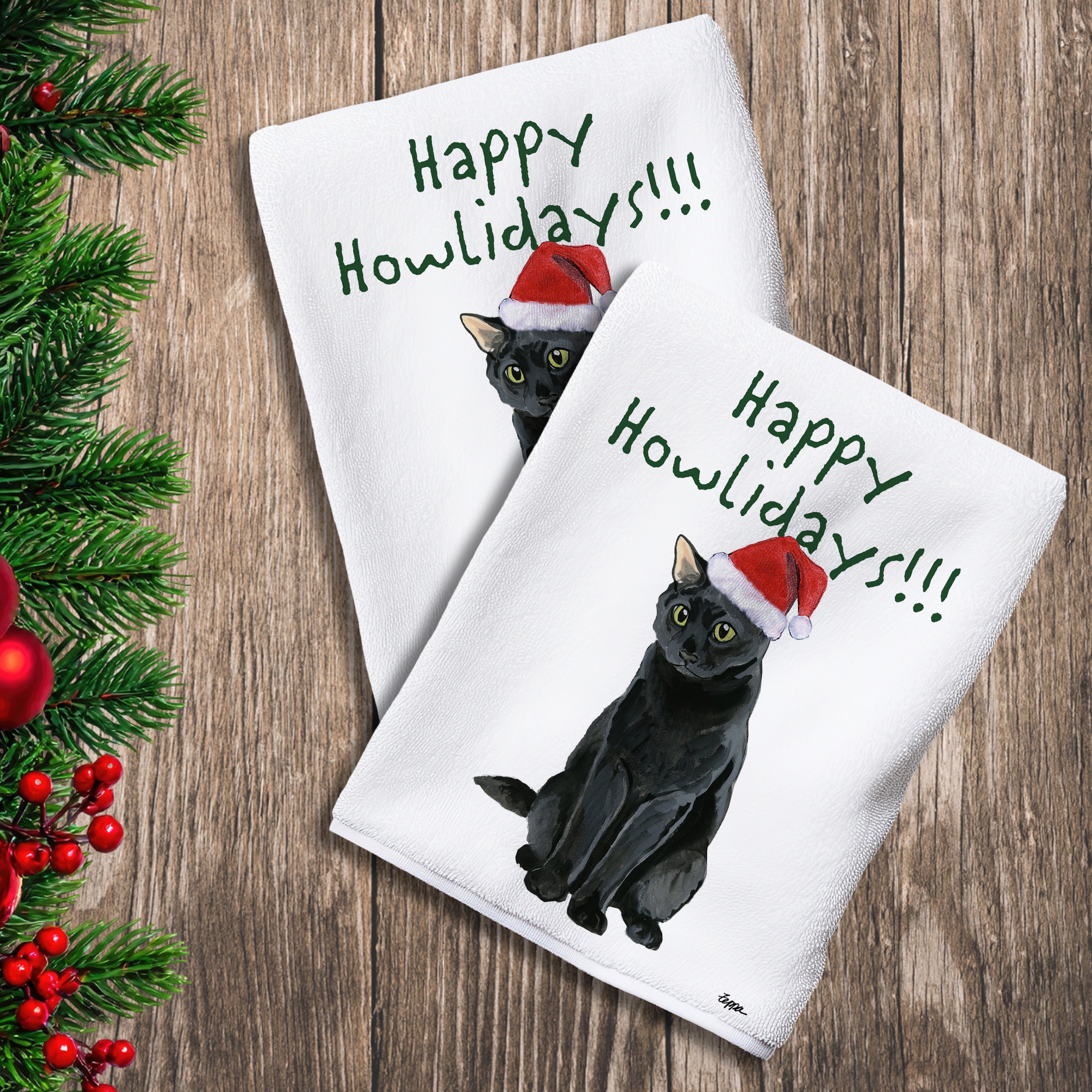 2 Kitchen Towels with a Black Cat in a Santa Hat and Happy Howlidays text.
