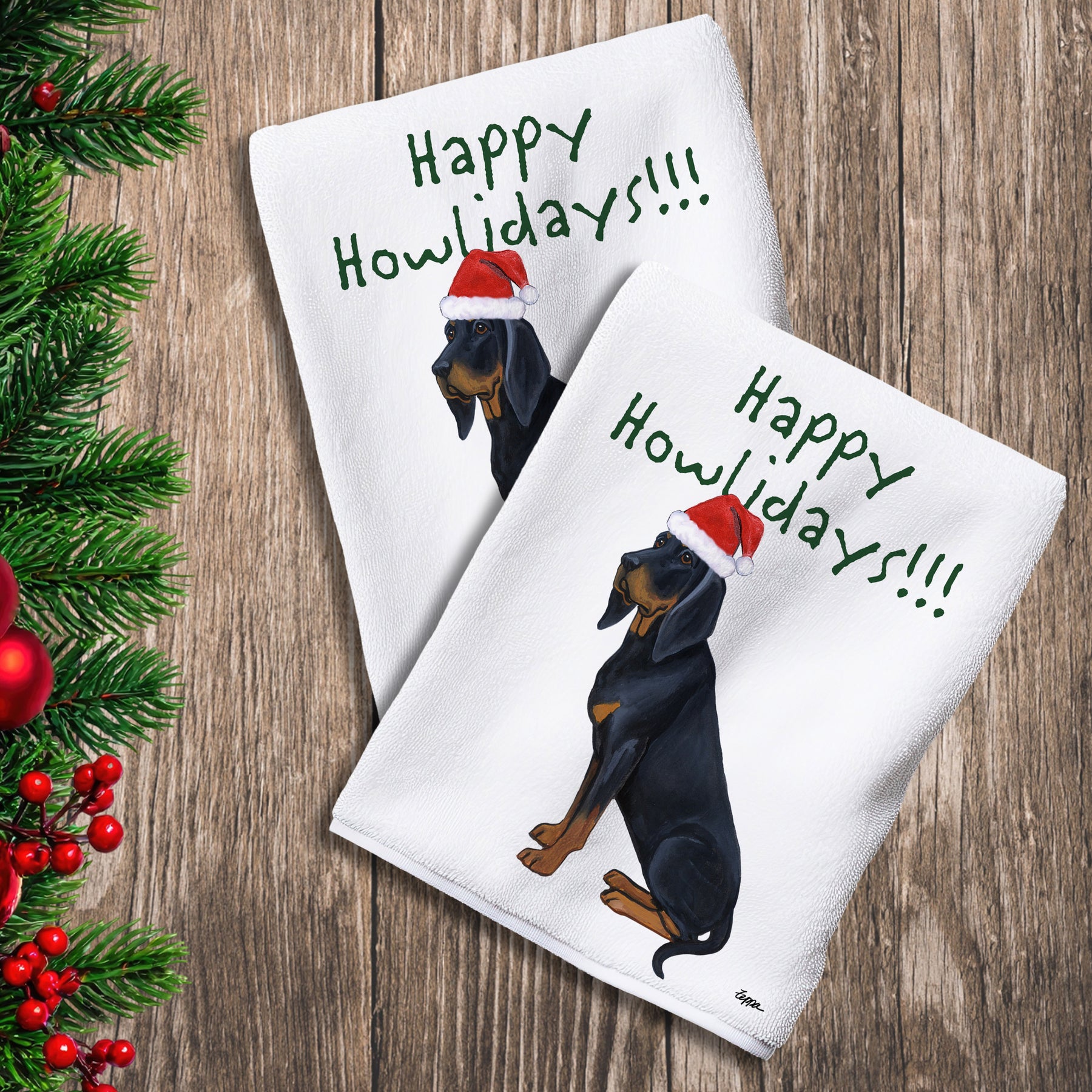 2 Kitchen Towels with a Black and Tan Coonhound in a Santa Hat and Happy Howlidays text.