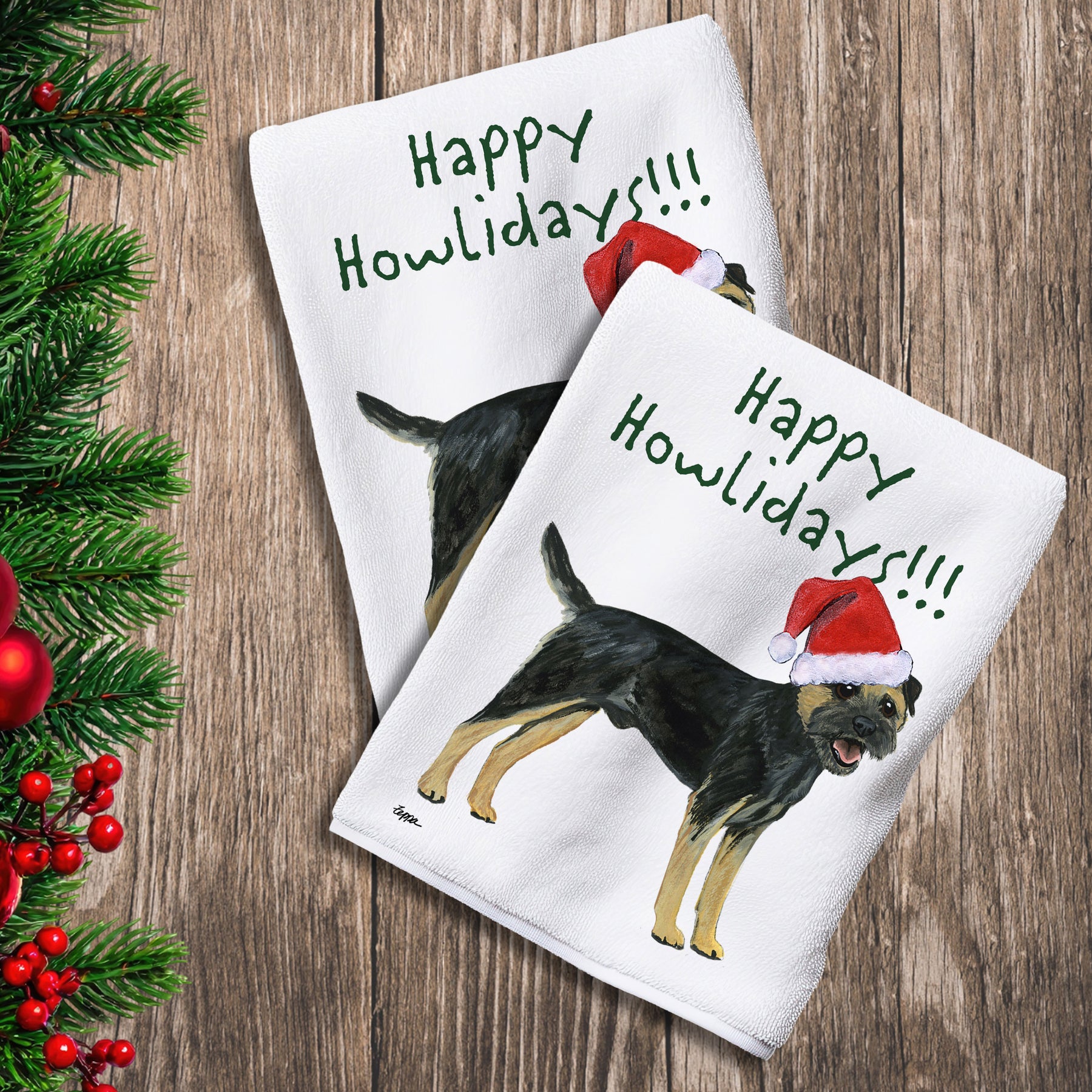 2 Kitchen Towels with a black and tan Border Terrier in a Santa Hat and Happy Howlidays text.