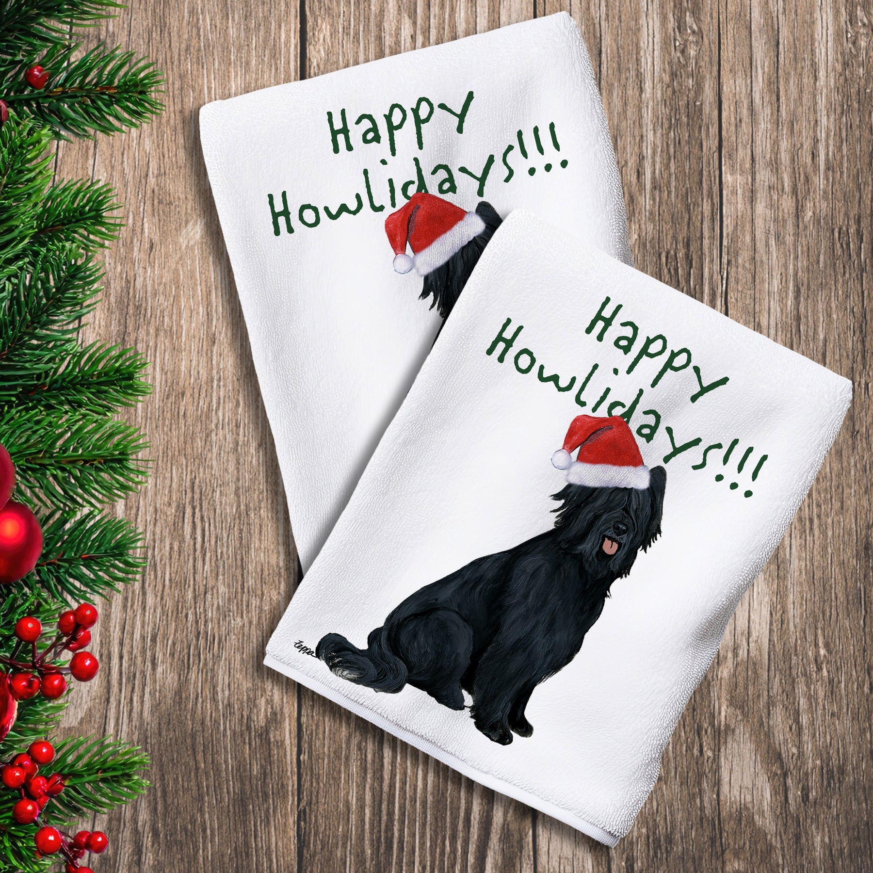 2 Kitchen Towels with a black Briard in a Santa Hat and Happy Howlidays text.