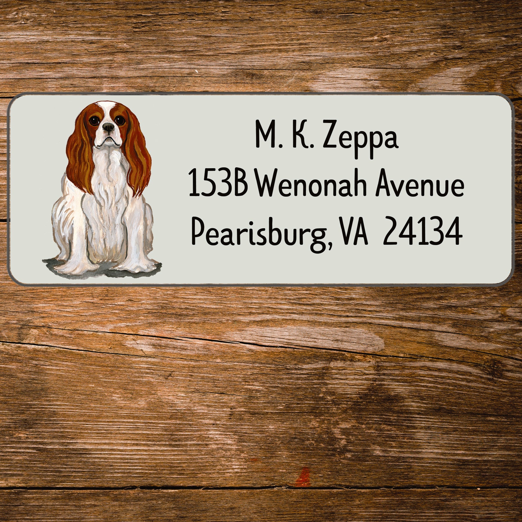 Return address label with a Cavalier King Charles Spaniel illustration.