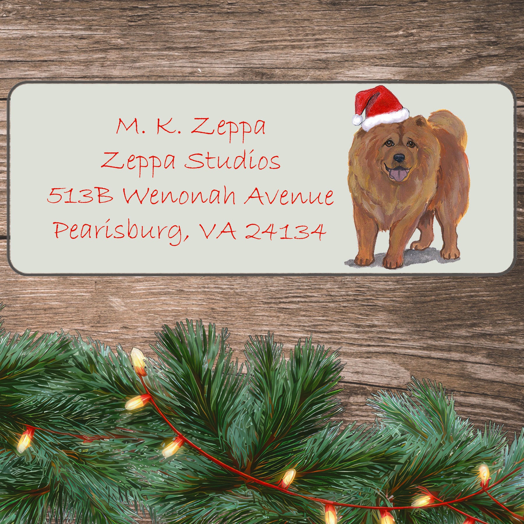 An illustration of a Chow Chow wearing a Santa Hat on an ivory return address label set off by a wood surface with holiday greenery background.