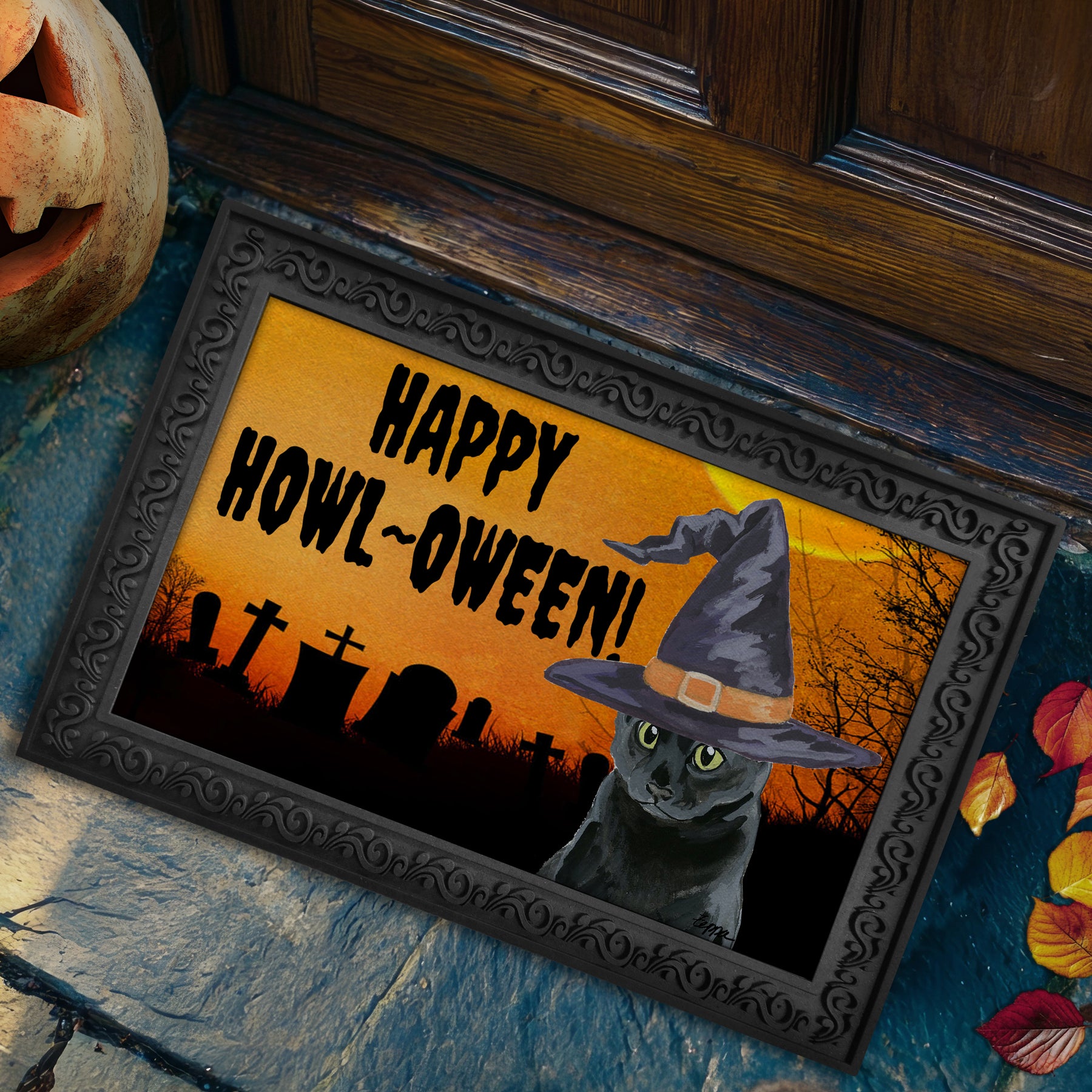 A black cat in a witch hat in a graveyard on a Happy Howl oween door mat