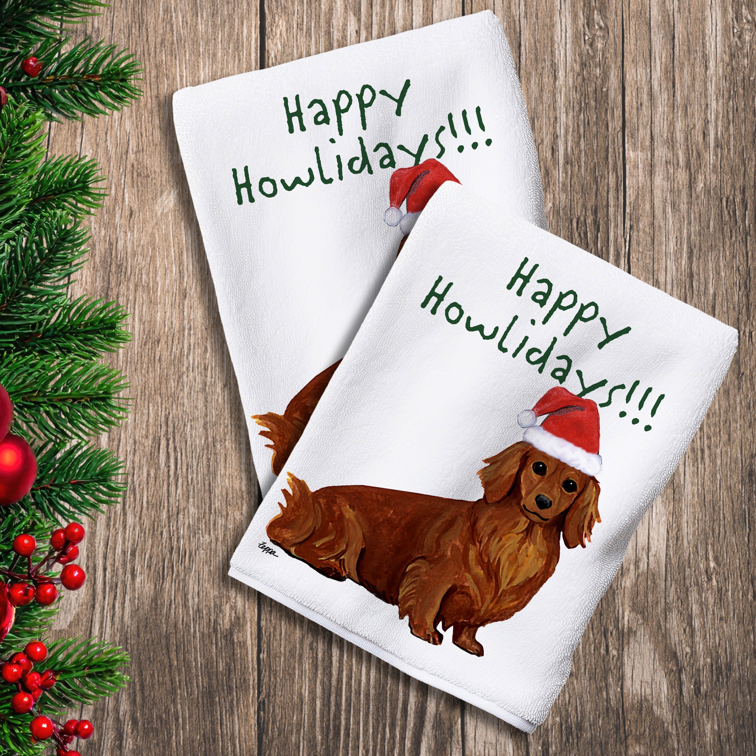 2 Kitchen Towels with a red longhaired Dachshund in a Santa Hat and Happy Howlidays text. 