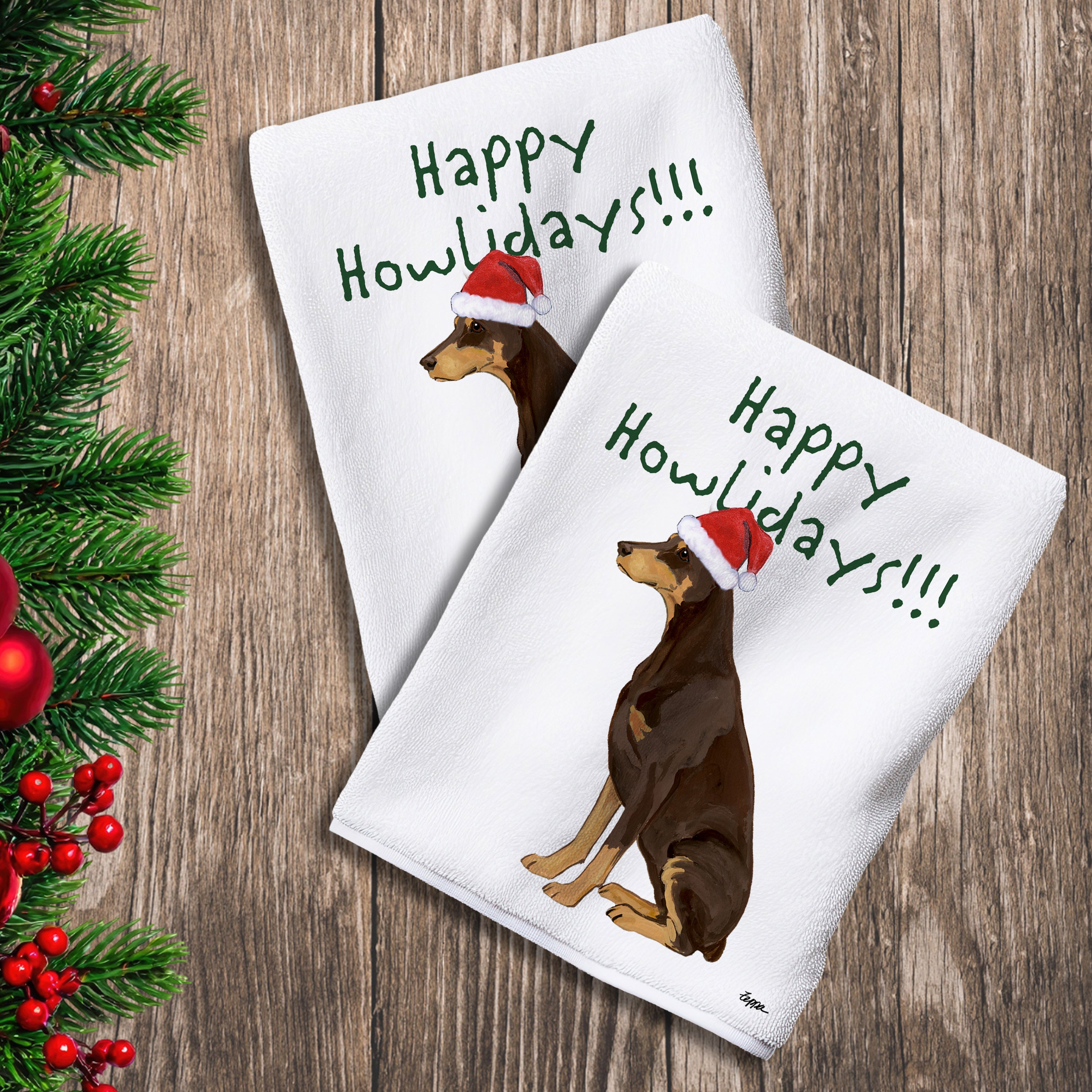 2 Kitchen Towels with a red Doberman in a Santa Hat and Happy Howlidays text. 