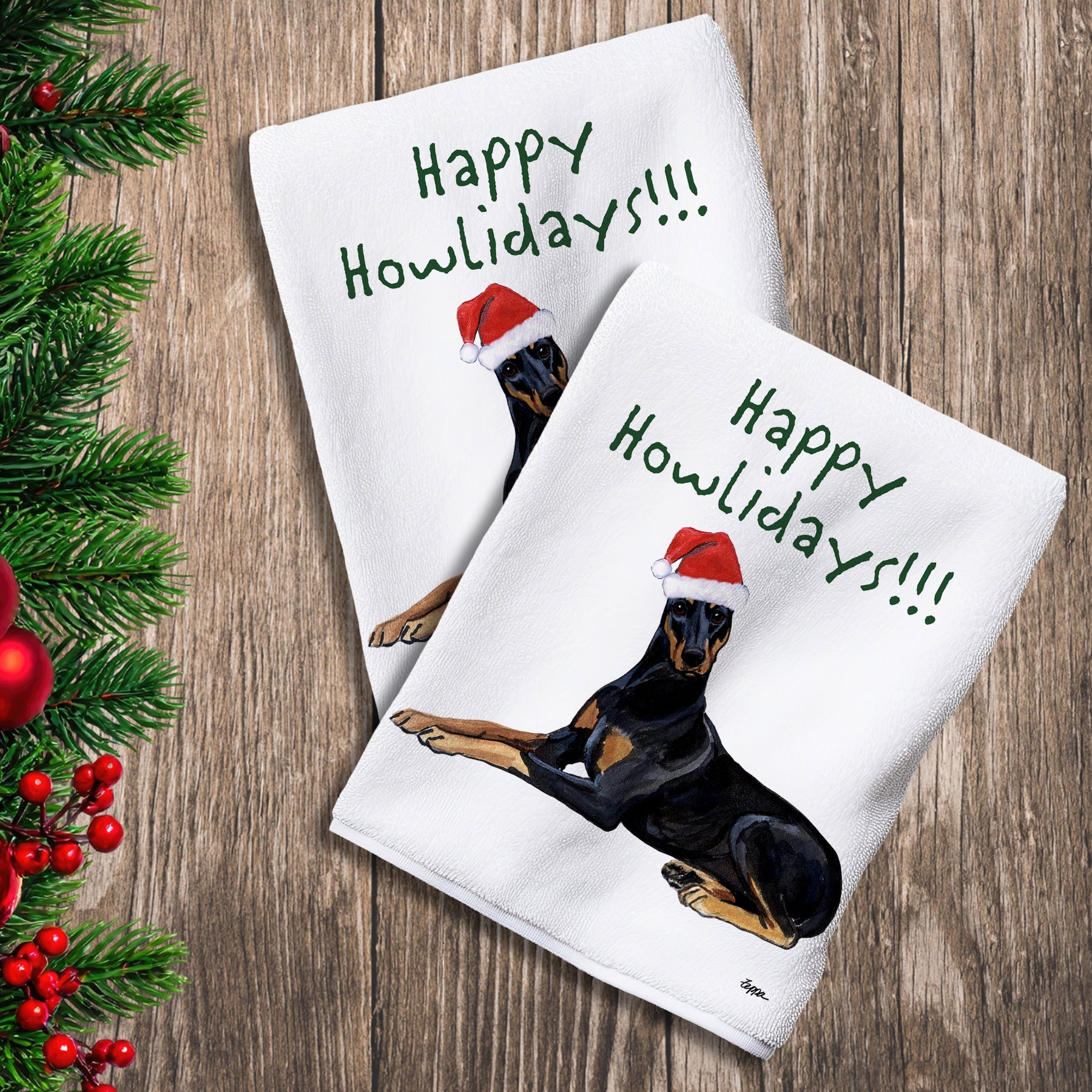 2 Kitchen Towels with a  Doberman in a Santa Hat and Happy Howlidays text. 