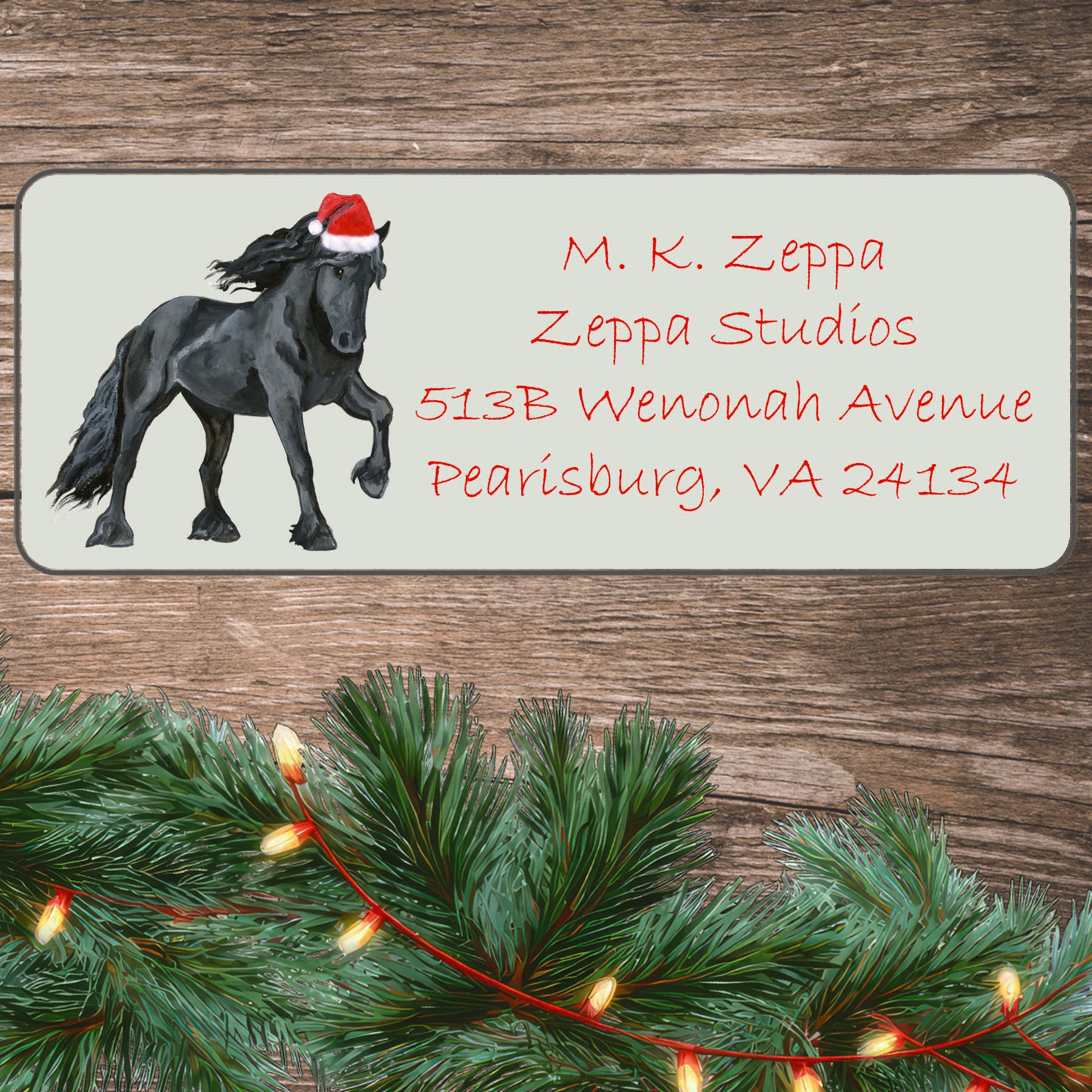A Friesian Horse in a Santa Hat illustration on an ivory return address label set off by a wood surface with holiday greenery background.