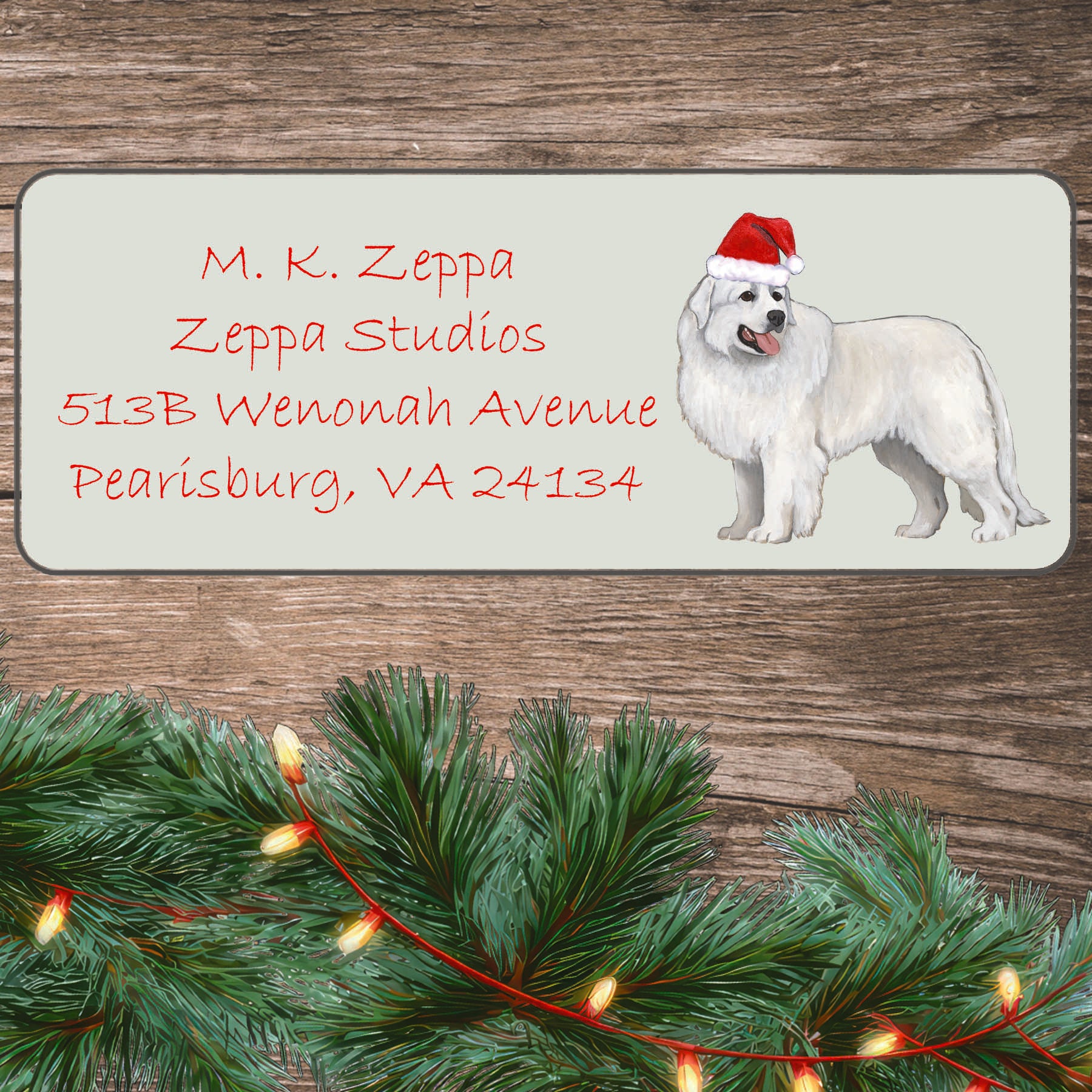 An illustration of a Great Pyrenees wearing a Santa Hat on an ivory return address label set off by a wood surface with holiday greenery background.