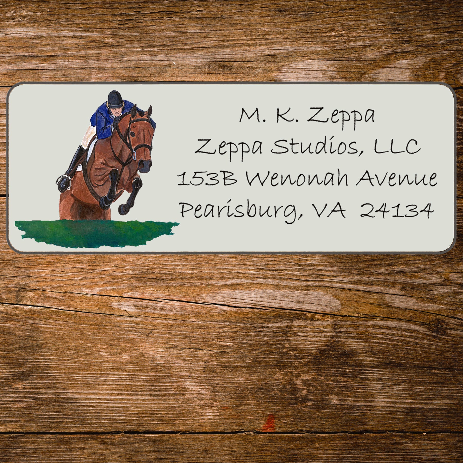 Return address label with horse and rider illustration on a wooden surface