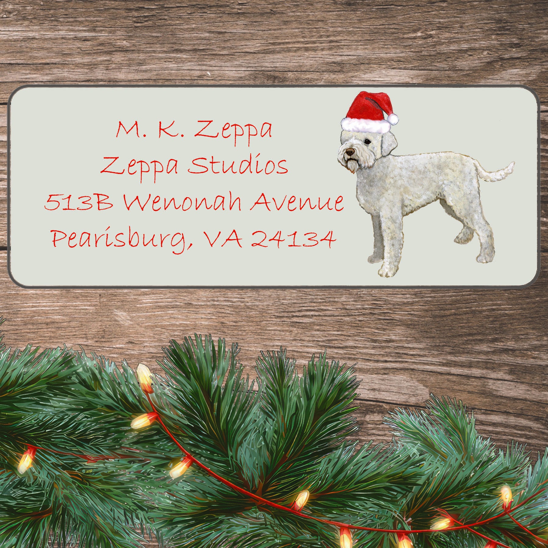 An illustration of a  Lagotto Romagnolo wearing a Santa Hat on an ivory return address label set off by a wood surface with holiday greenery background.