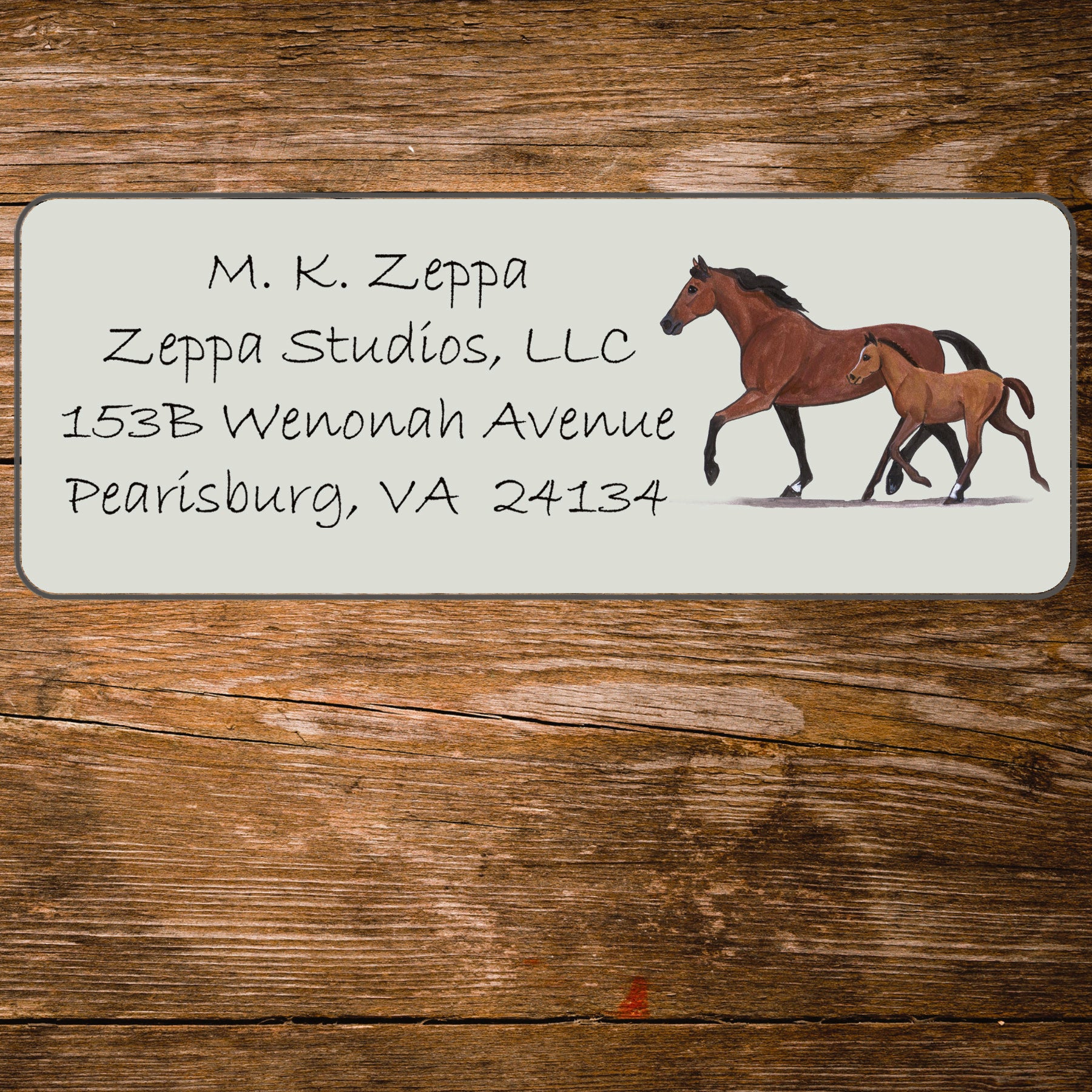 Address label with a mare and foal illustration on a wooden background