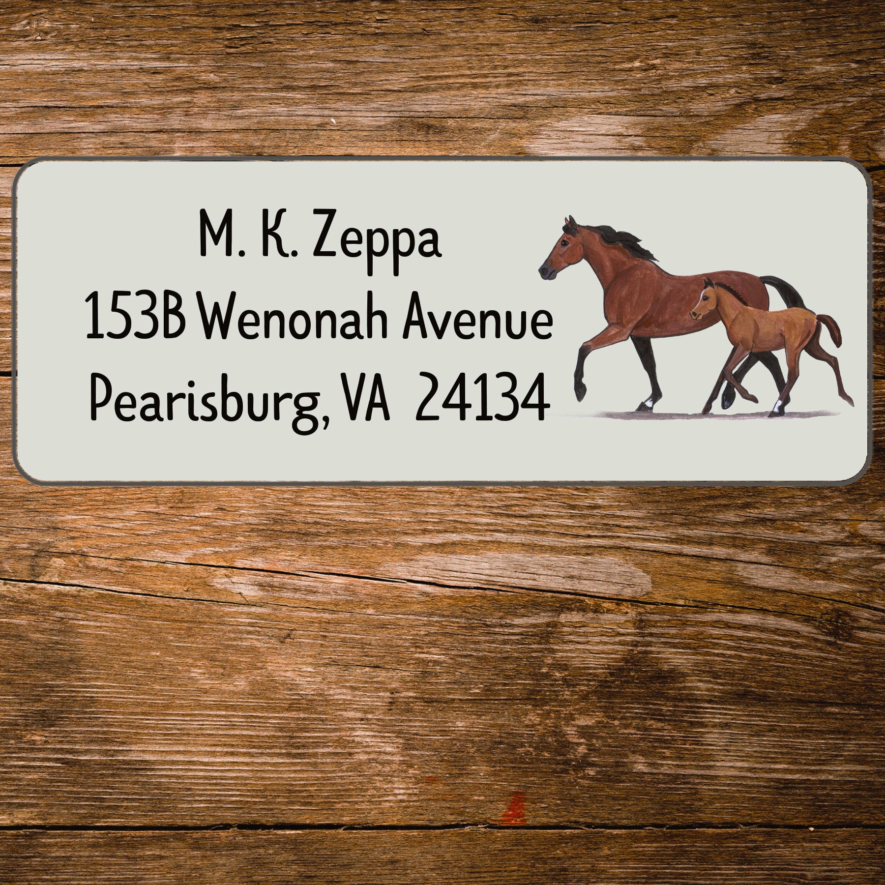 Address label with a mare and foal illustration on a wooden background
