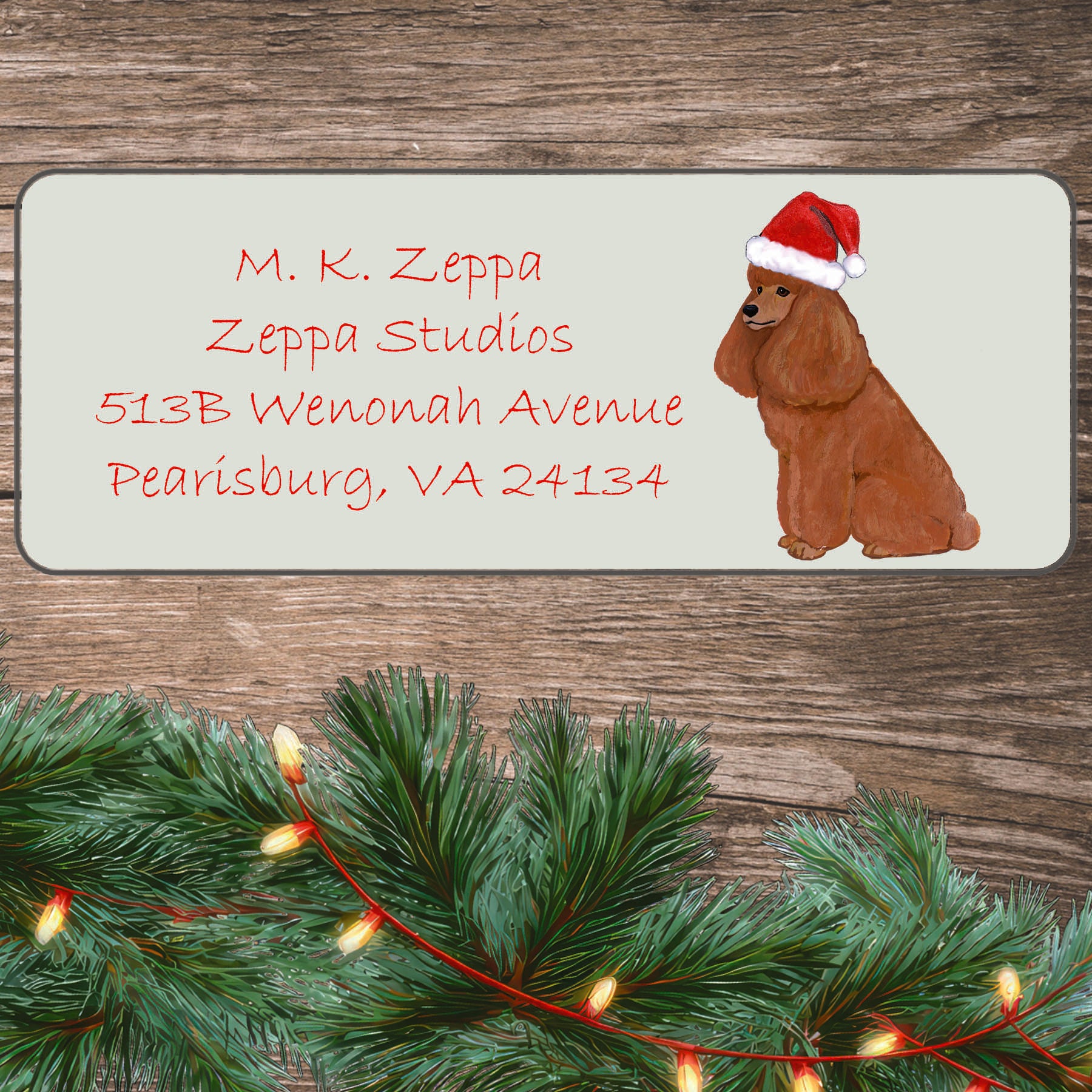 An illustration of an apricot Poodle  wearing a Santa Hat on an ivory return address label set off by a wood surface with holiday greenery background.
