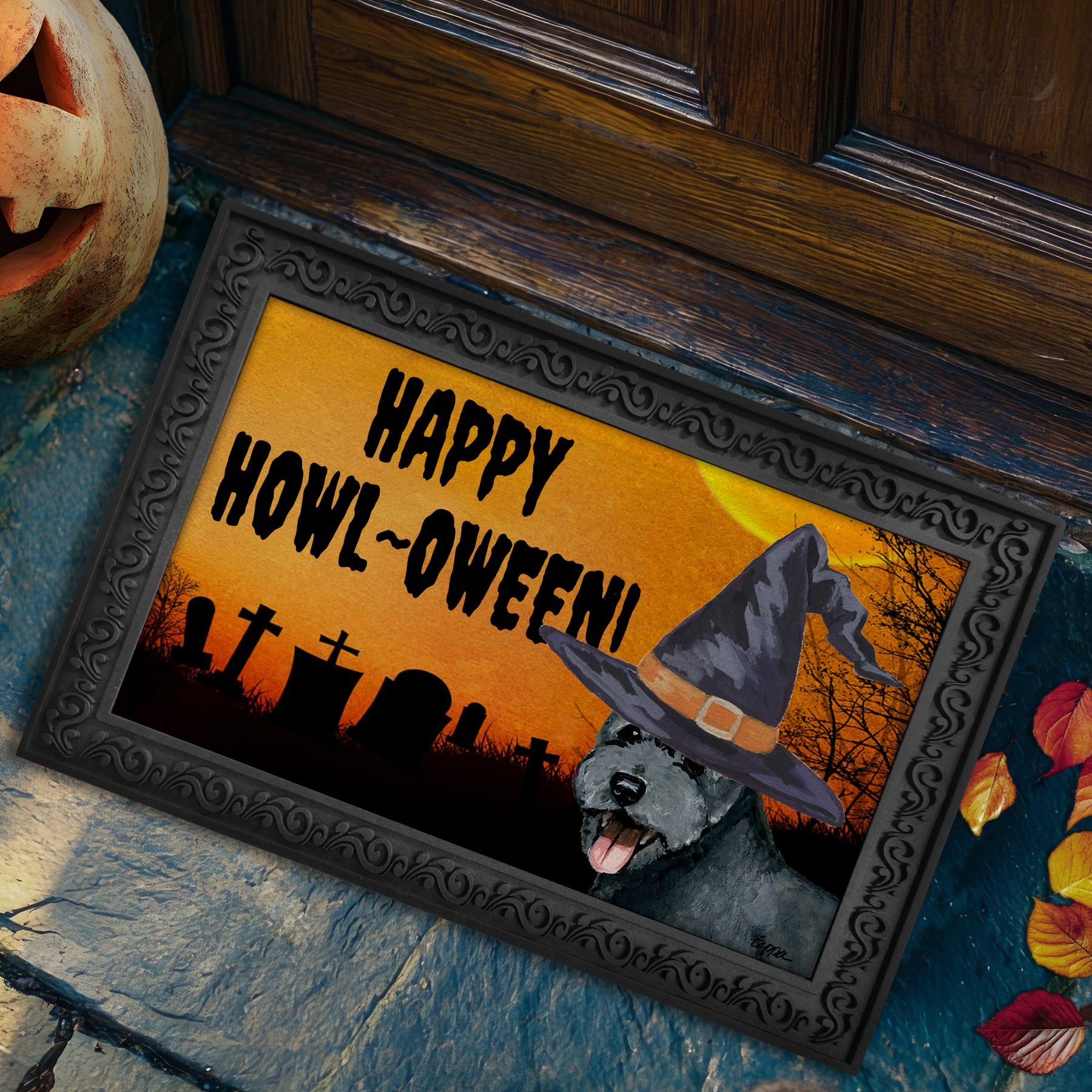 Pumi in a witch's hat on a Happy Howl-ween doormat.