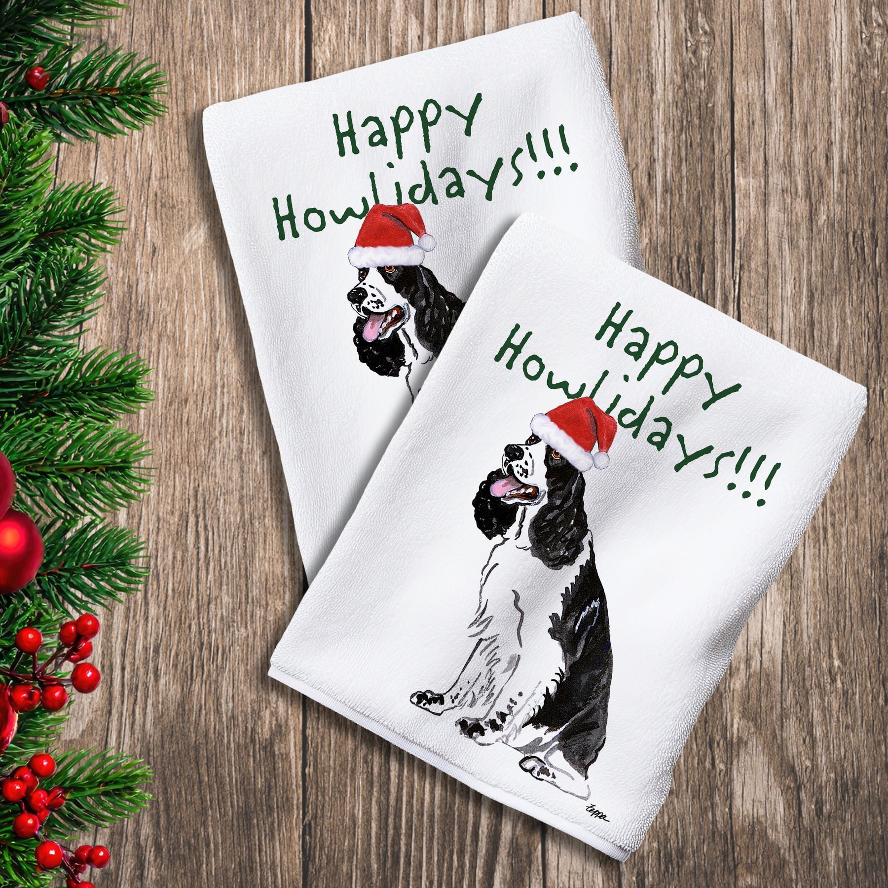 2 Kitchen Towels with a black and white Springer Spaniel in a Santa Hat and Happy Howlidays text.
