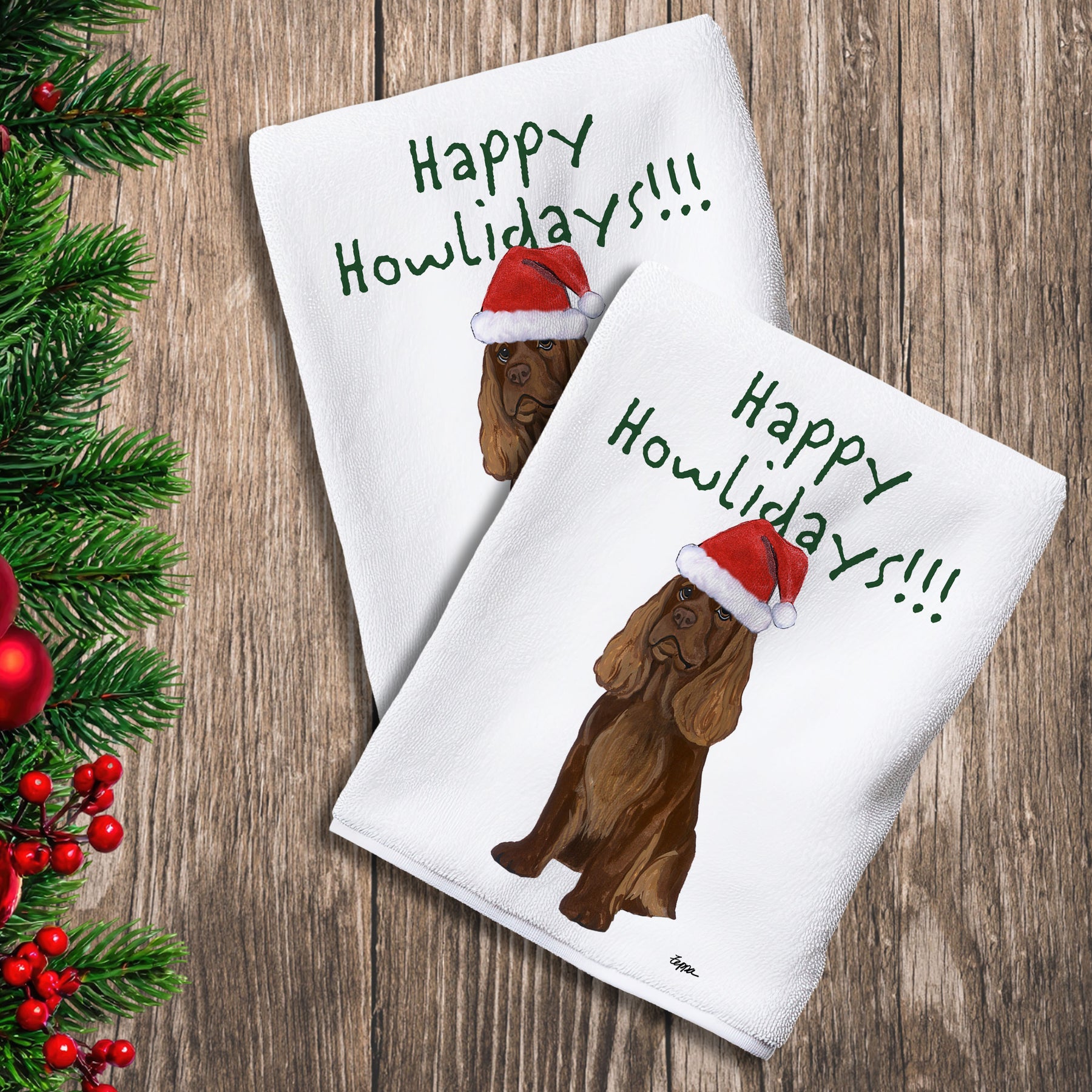 2 Kitchen Towels with a Sussex Spaniel in a Santa Hat and Happy Howlidays text.
