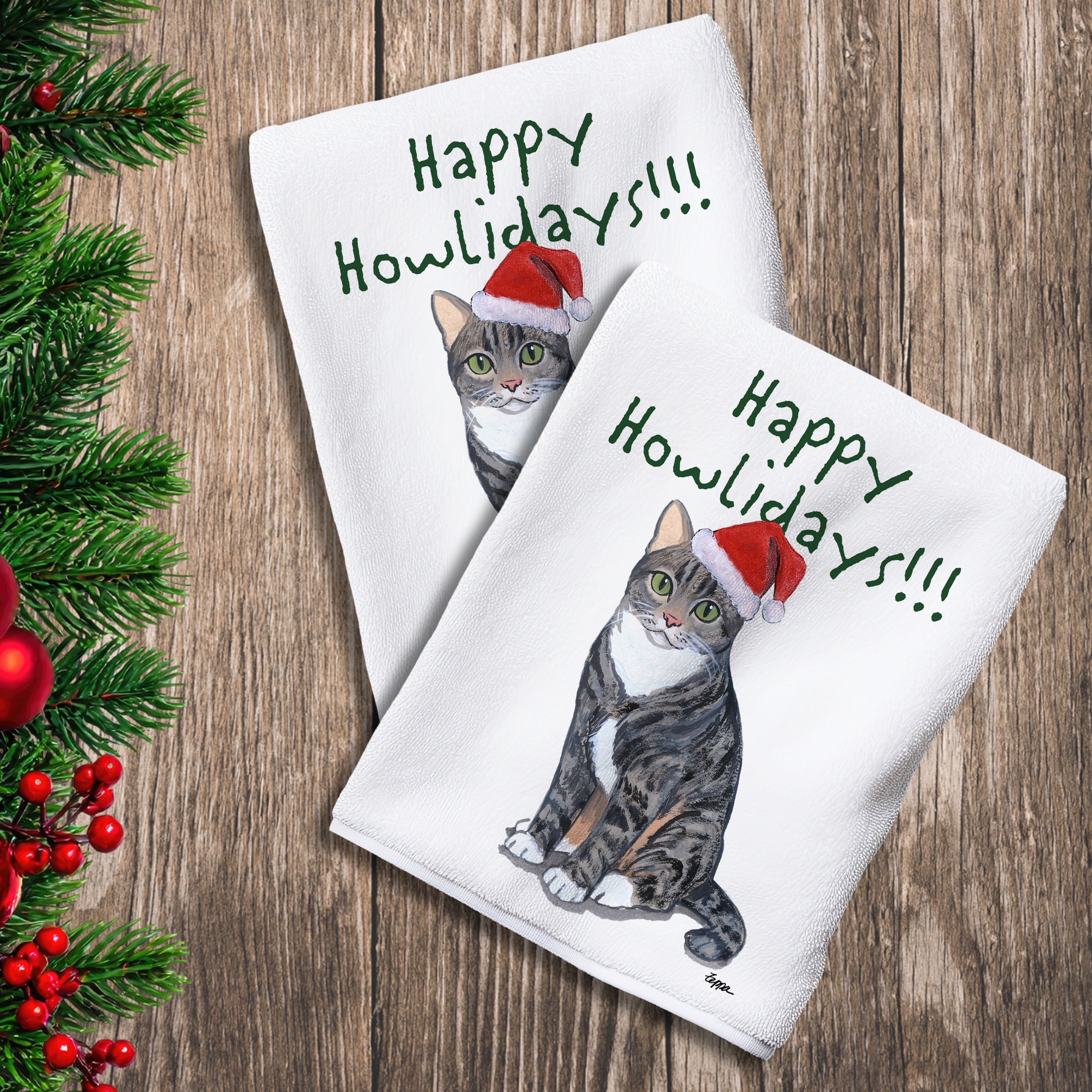 2 Kitchen Towels with a Tabby Cat in a Santa Hat and Happy Howlidays text.
