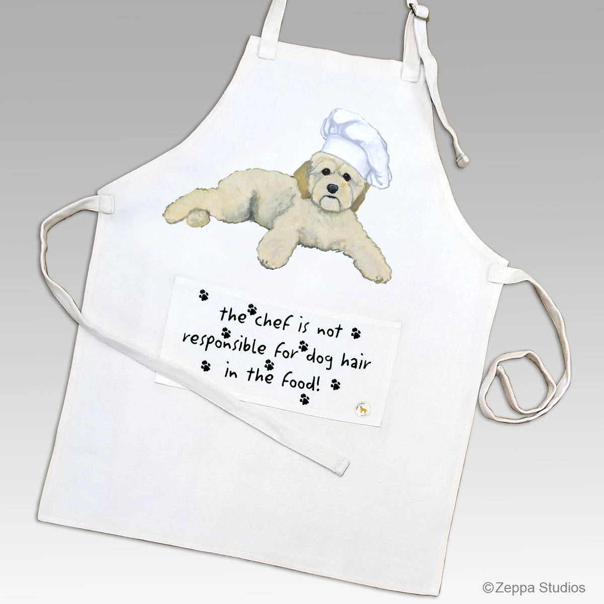 Cockapoo in a chef's hat on an apron with a funny saying on the pocket.