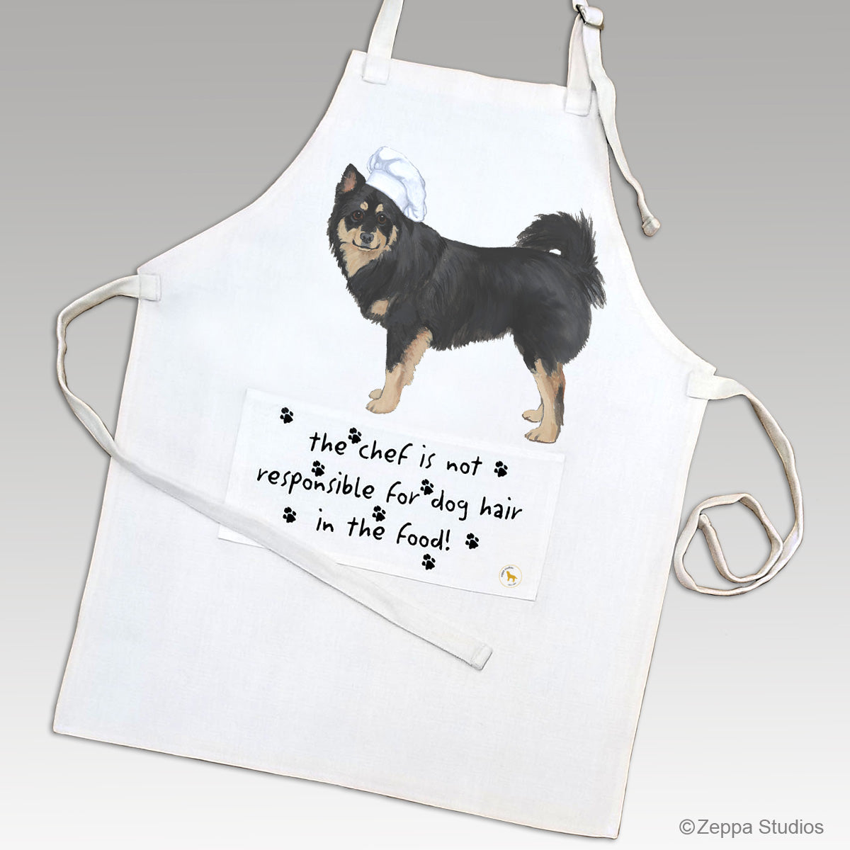 Finnish Lapphund in a chef's hat on an apron with a pocket with funny text.