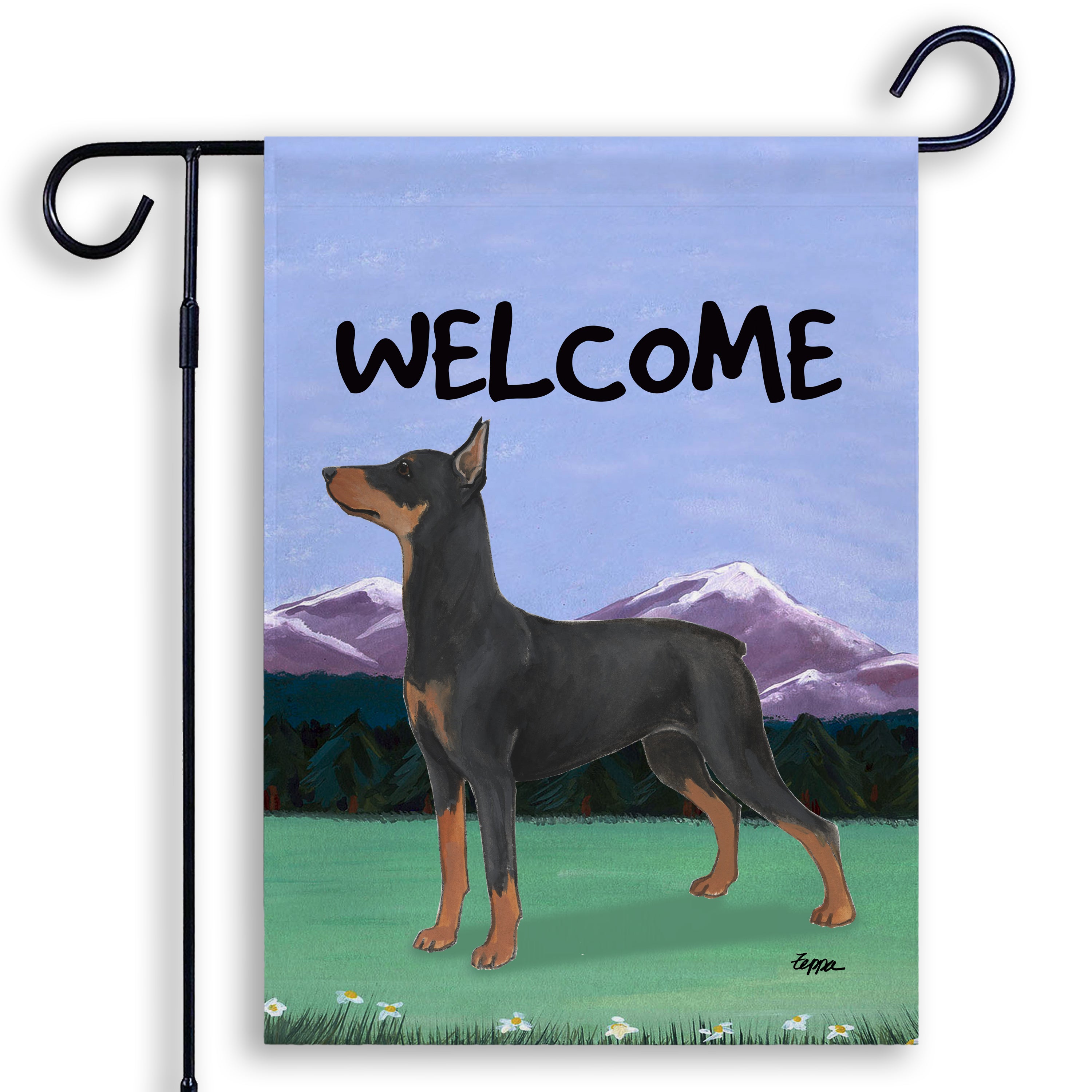 German Pinscher in a mountain setting on a garden flag saying Welcome.
