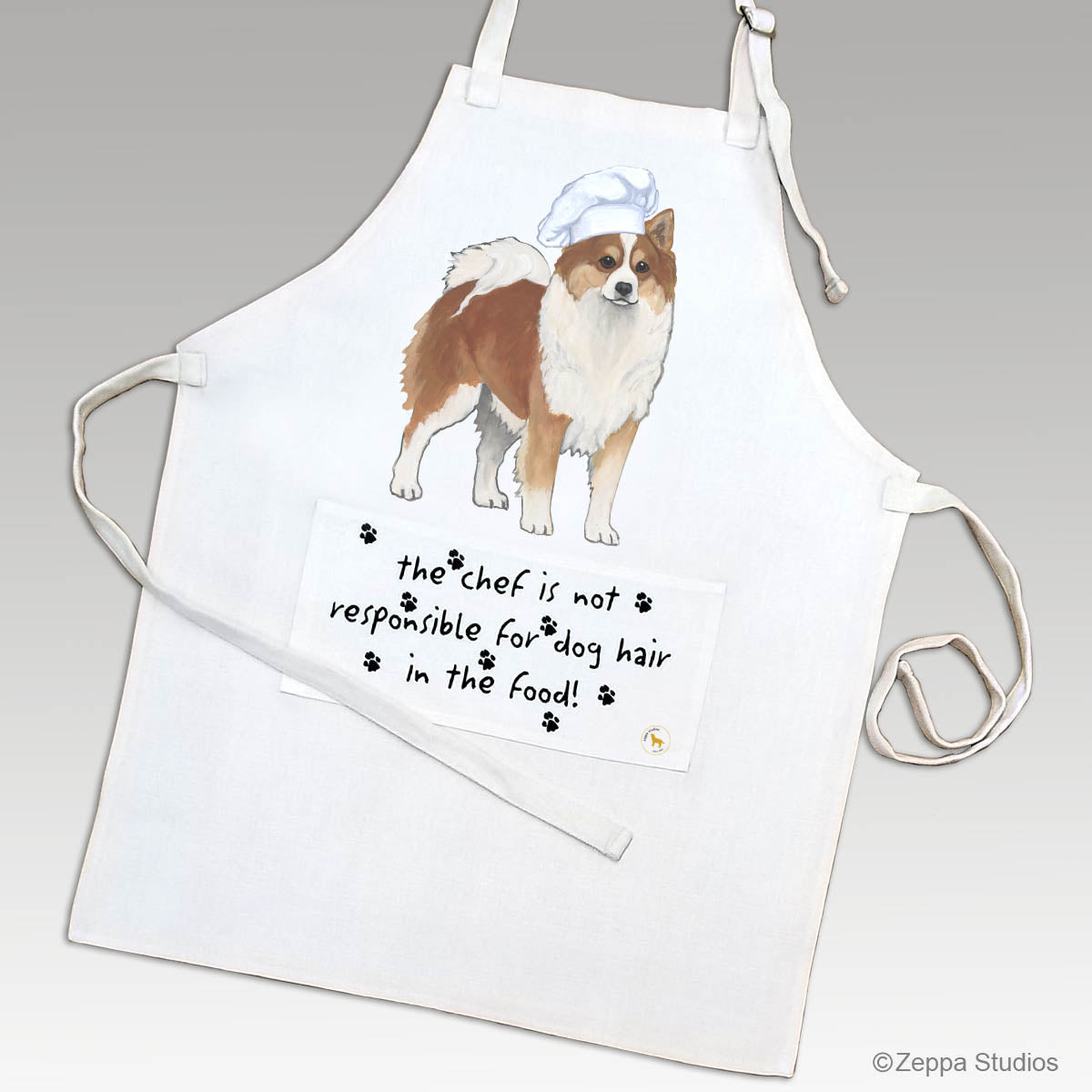 Icelandic Sheepdog wearing a chef hat on an apron.