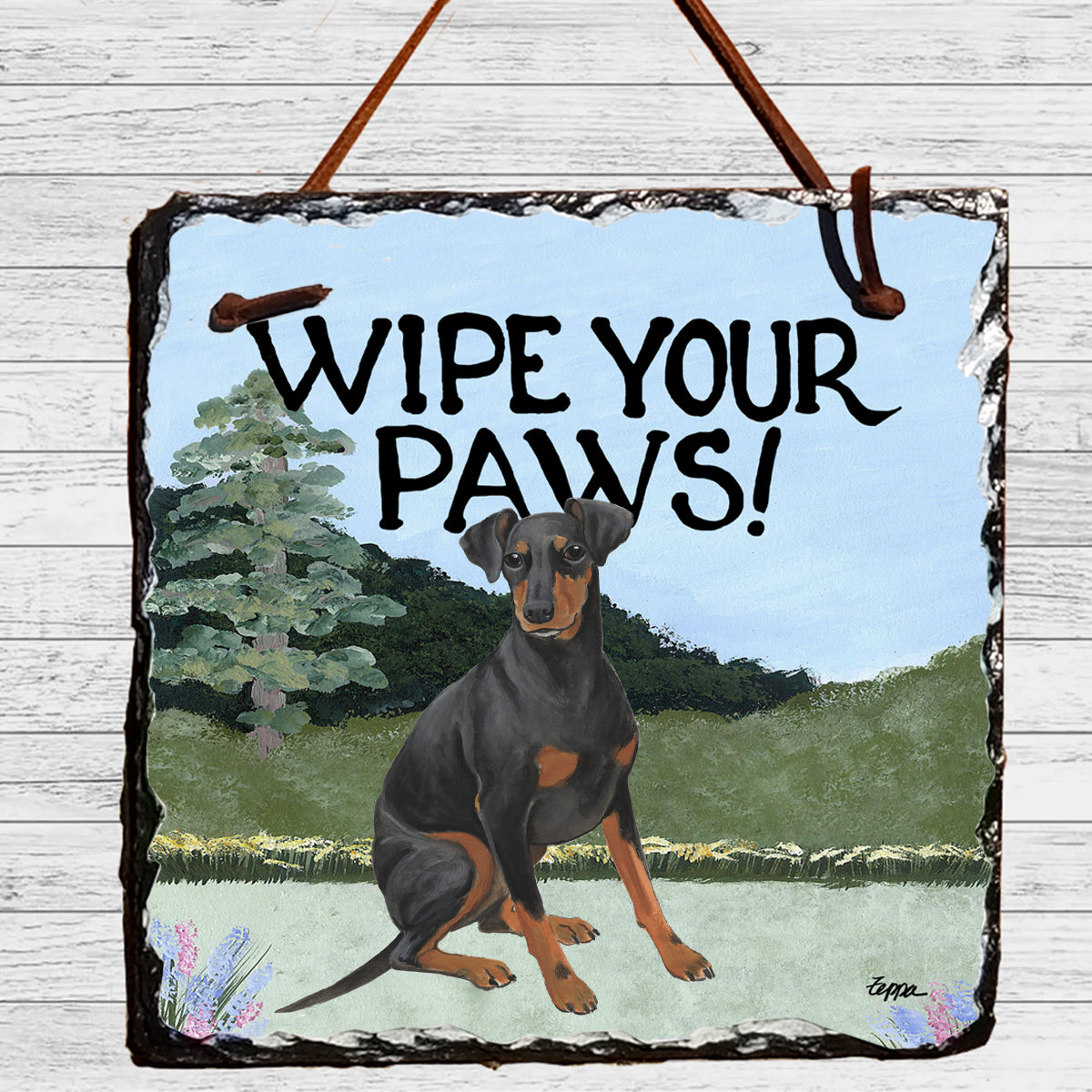 Manchester Terrier in a yard scene on a hanging slate Wipe Your Paws sign.