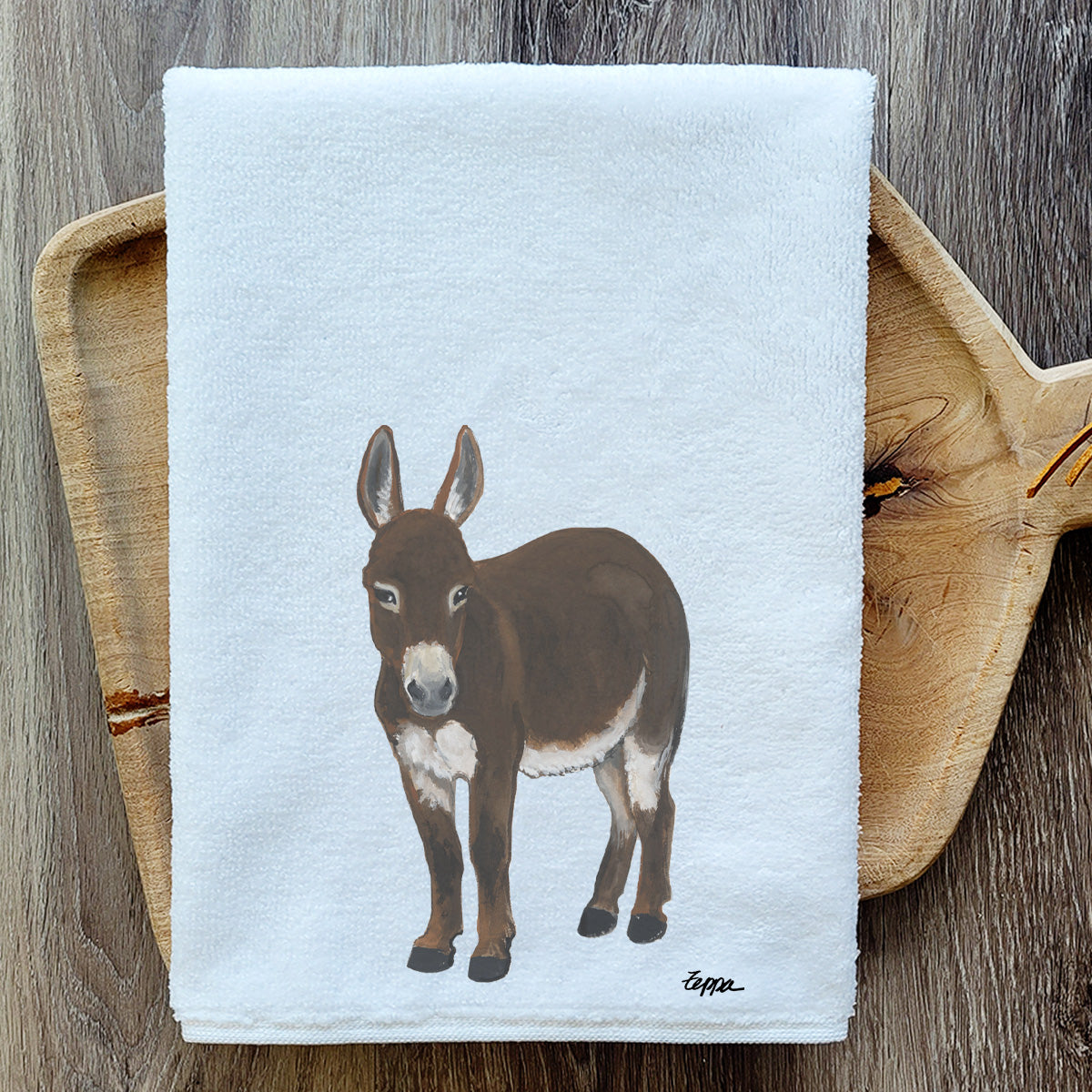 Mini Donkey design on a velour kitchen towel resting on a wooden serving board.