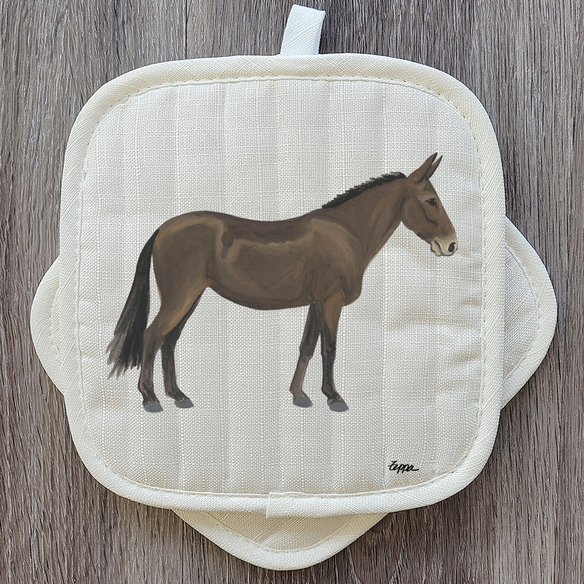A cream-colored quilted pot holder featuring a Mule illustration.