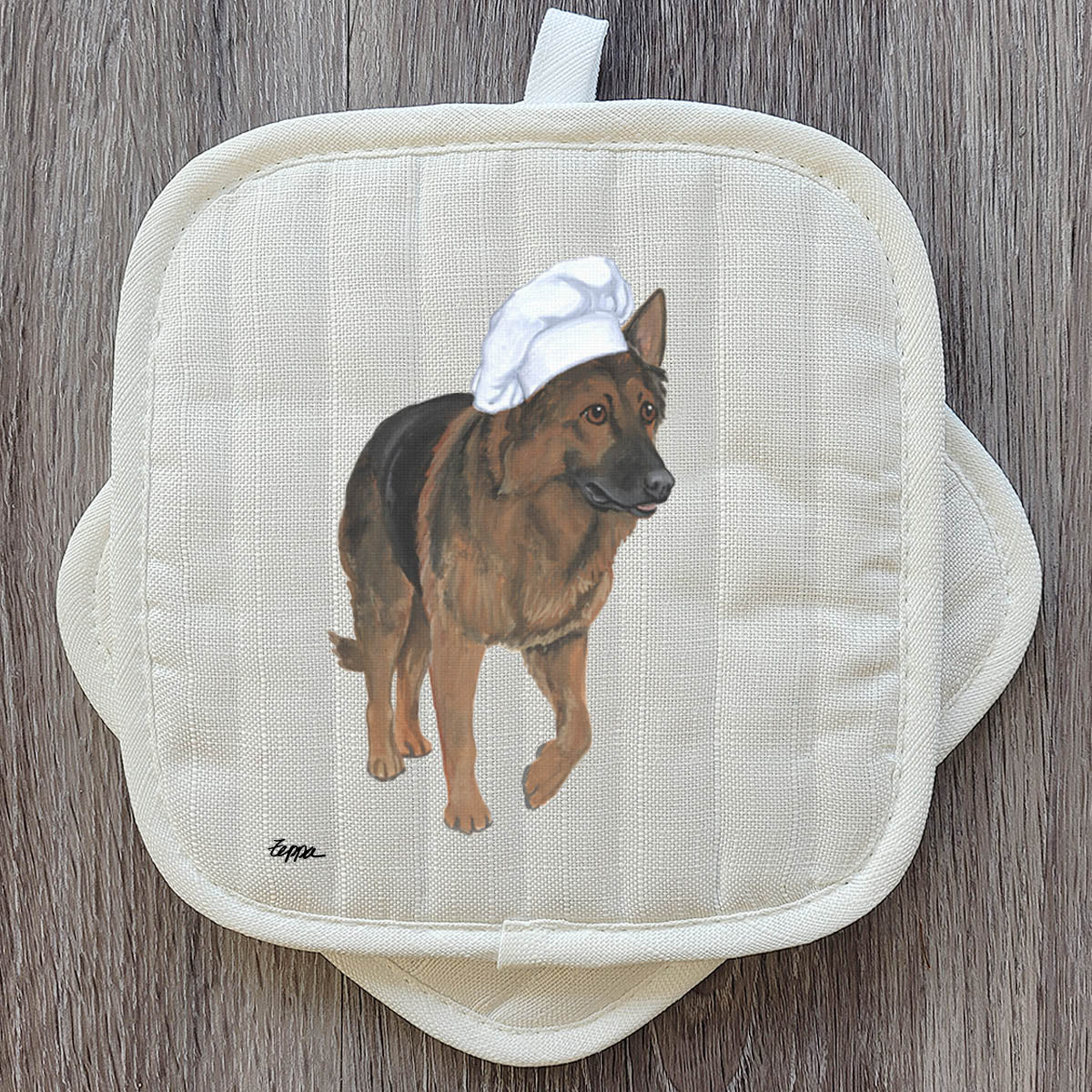 Shiloh Shepherd in a chef's hat on a set of  beige pot holders