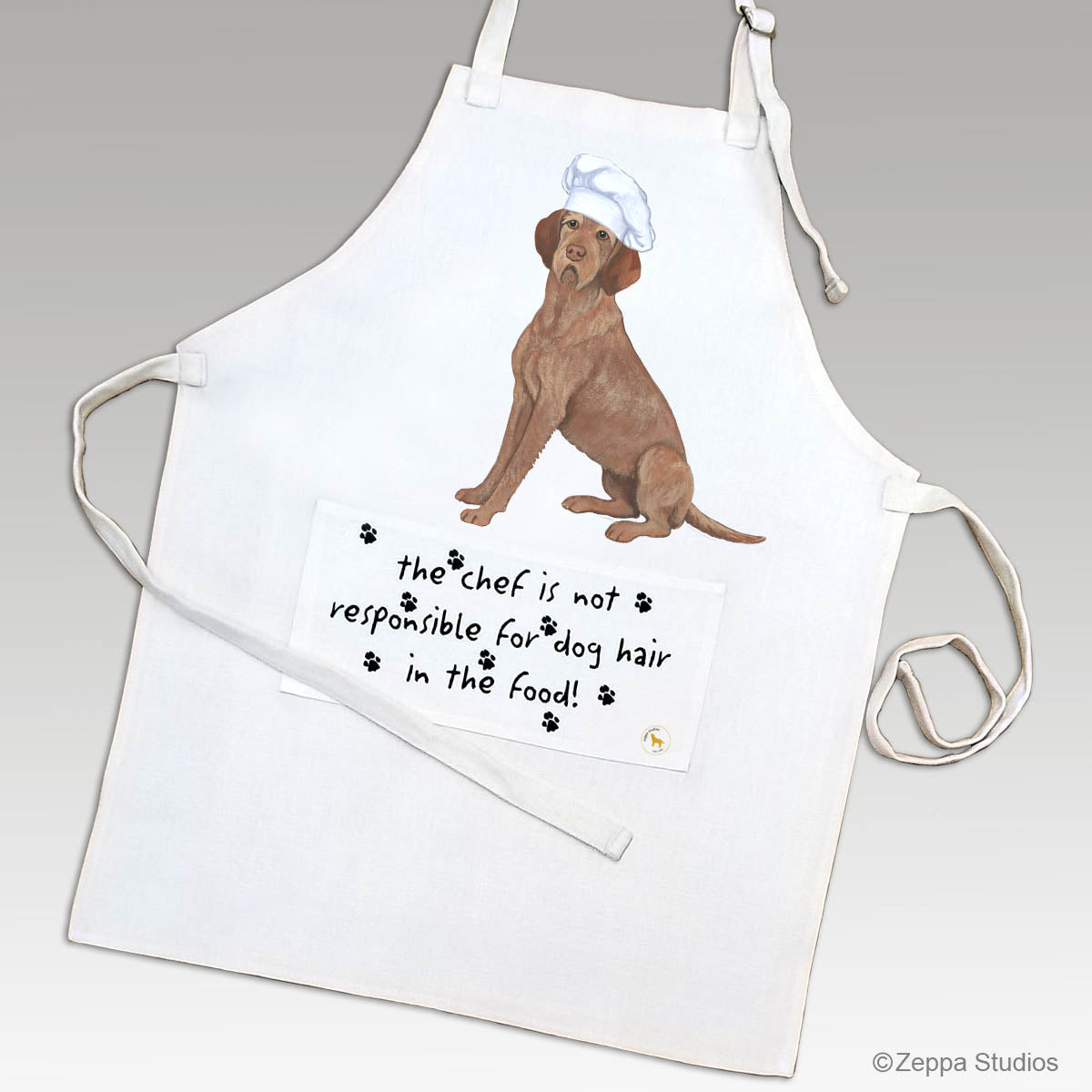 Wirehaired Vizsla in a chef's hat on an apron with a funny saying on the pocket.