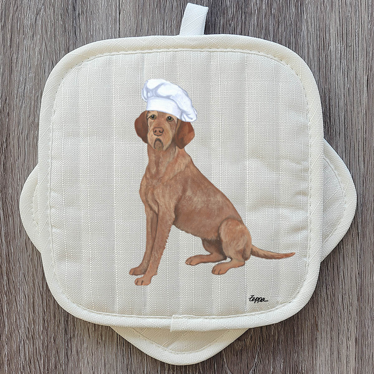 Wirehaired Vizsla in a Chef's hat on beige potholders